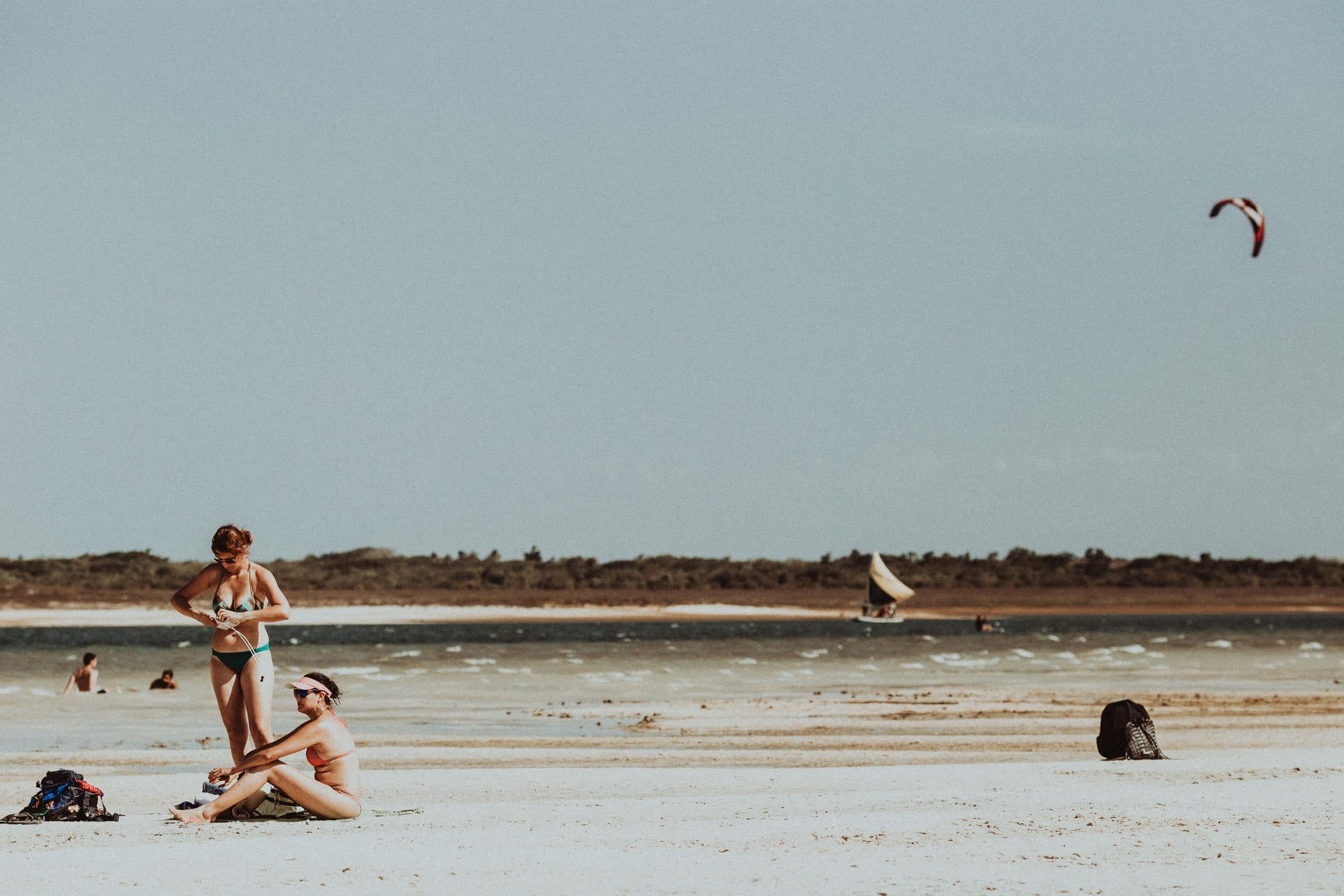 Pessoas aproveitam o sol e praticam windsurf na praia de Jericoacoara, no Ceará