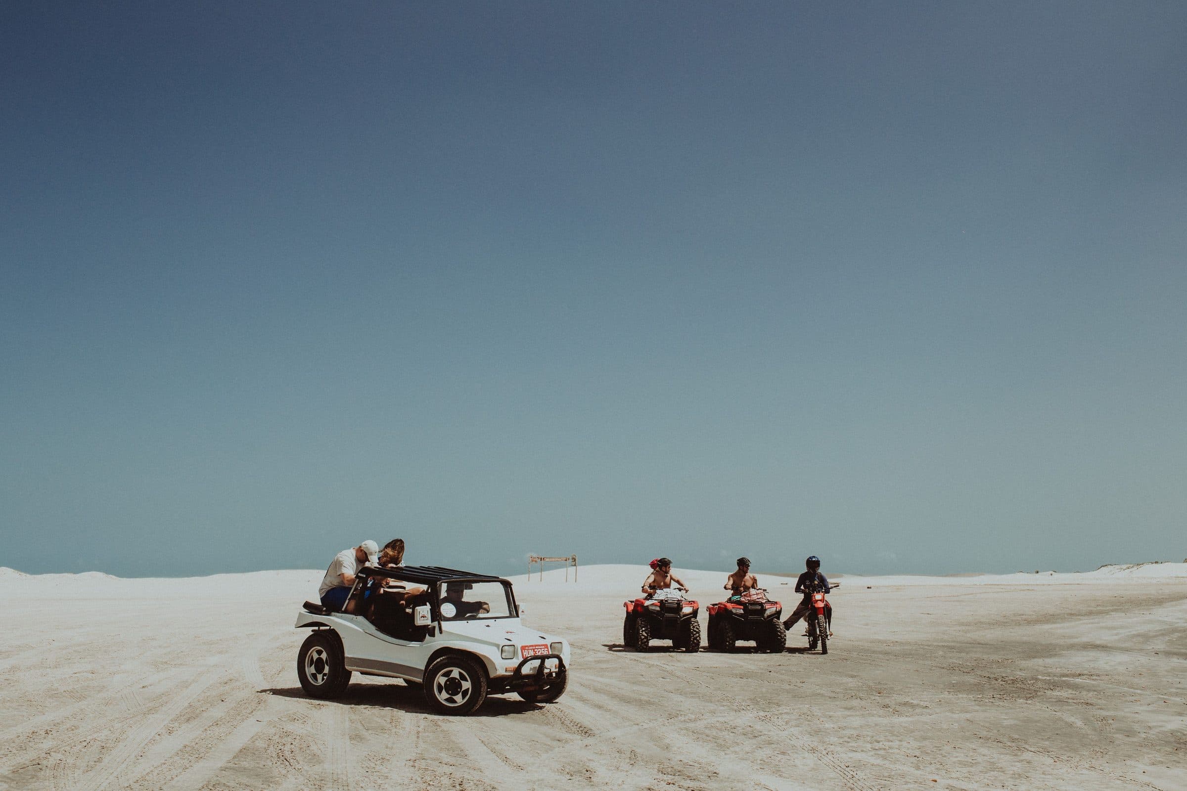 Pessoas pilotando buggies e quadriciclos pelas dunas de areia no Ceará