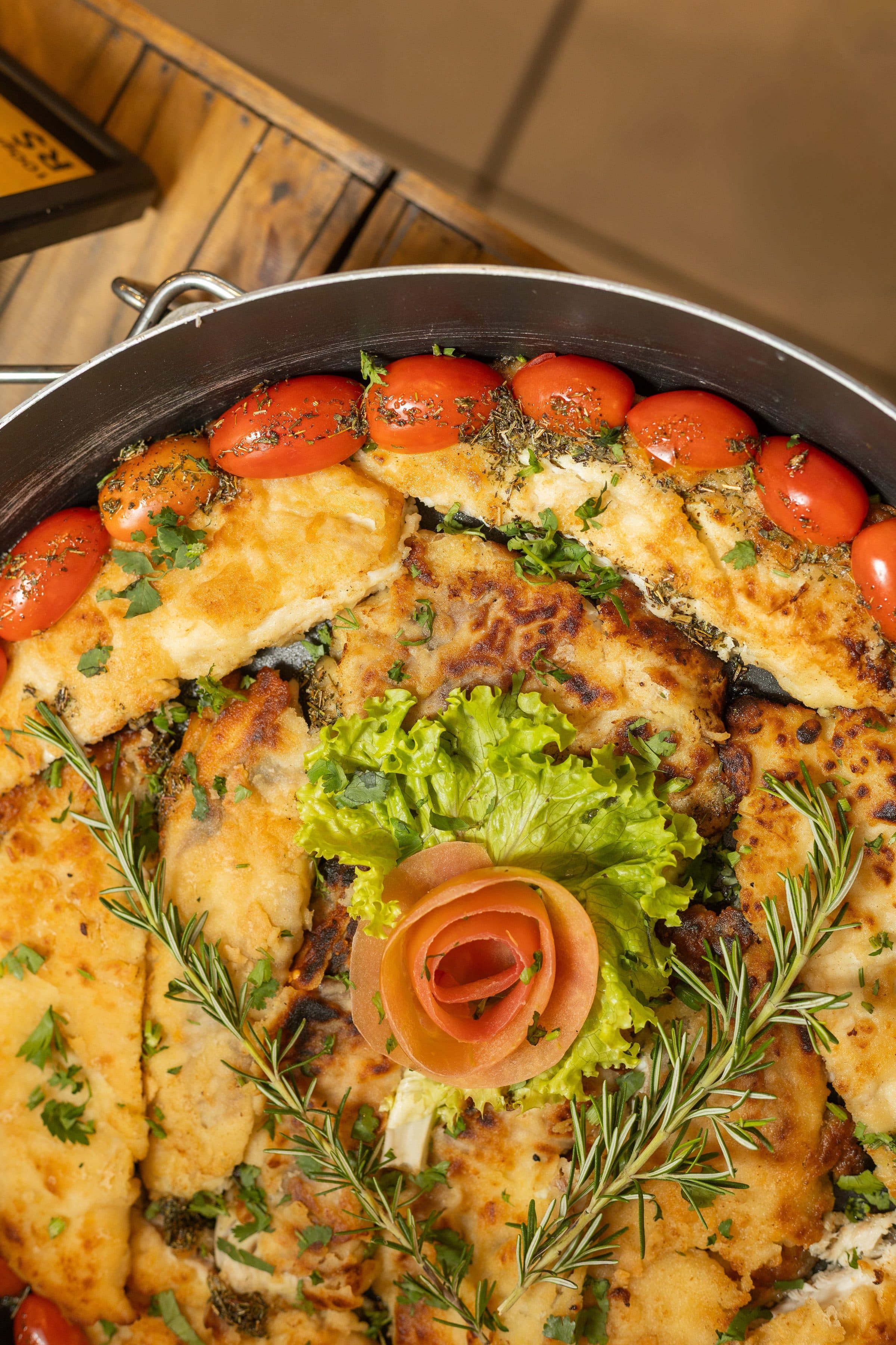 Prato de frango decorado com tomates-cereja e ramo de alecrim em close