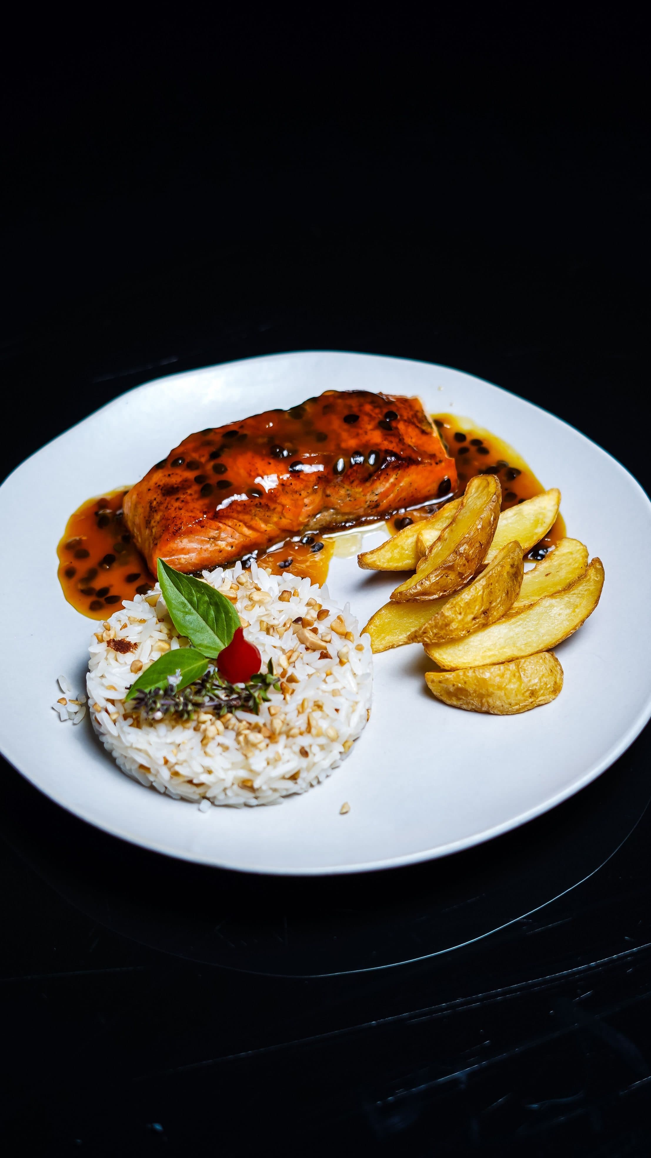 Prato com salmão laqueado, arroz temperado e batatas rústicas douradas