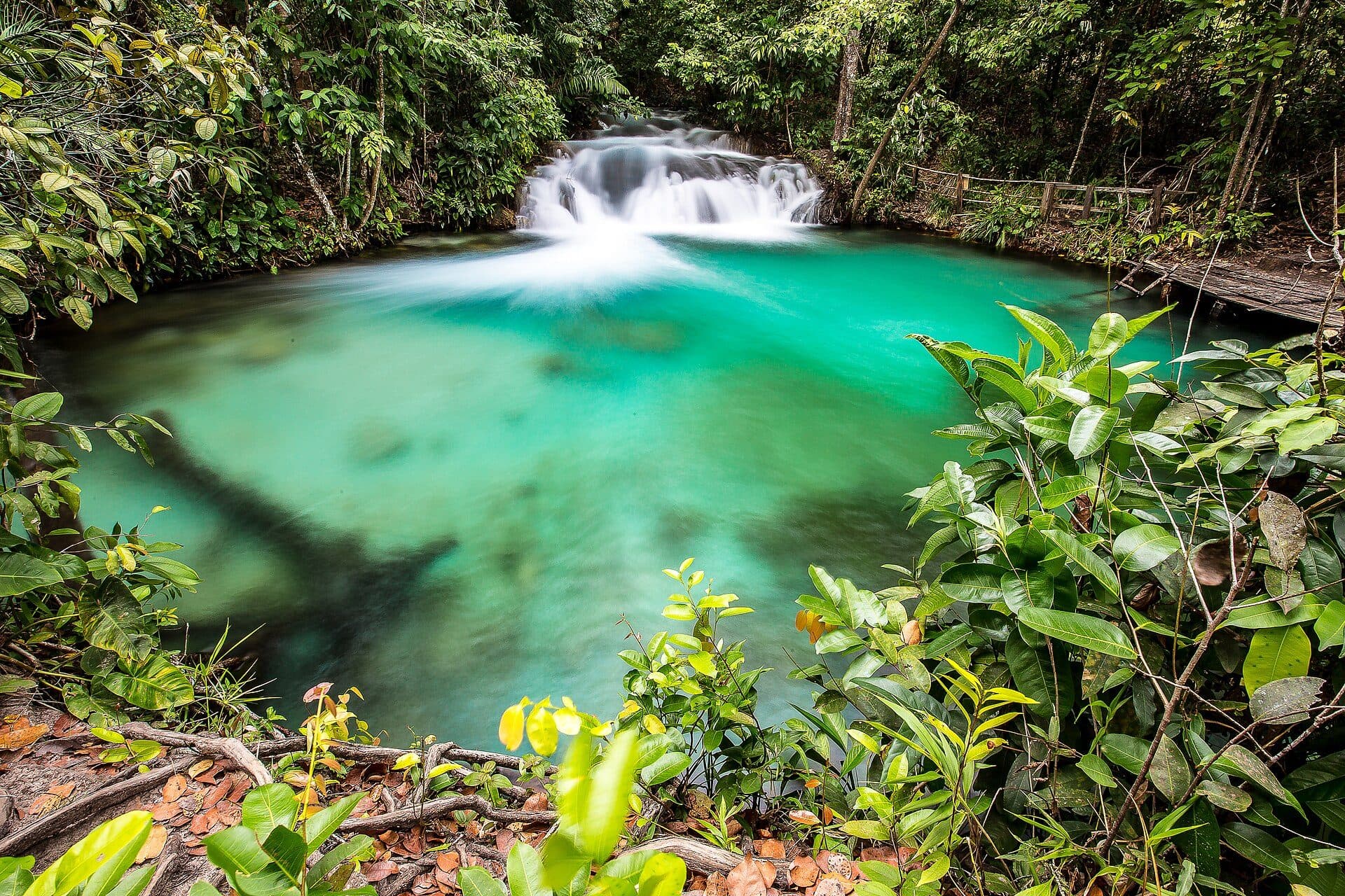 Cachoeira do Formiga com queda d'água e poço de águas azuis cristalinas cercados por vegetação