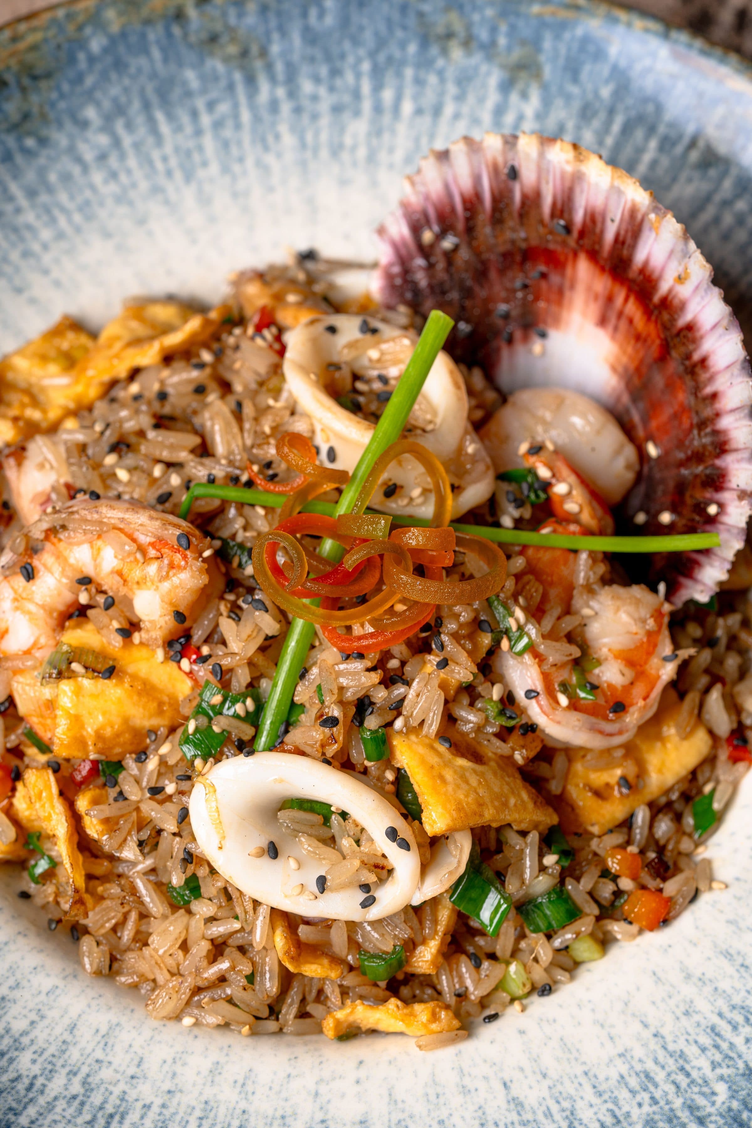 Arroz frito com frutos do mar, camarões, lula e vieiras visto de perto