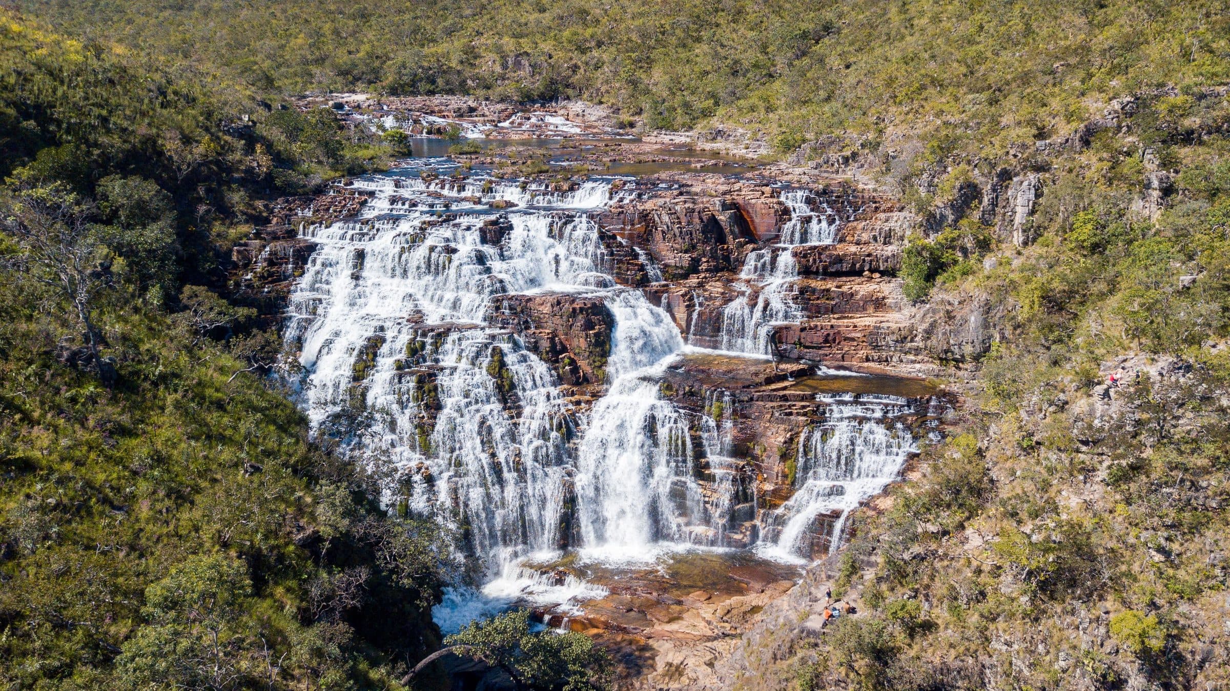 Cachoeiras em cascata cercadas por vegetação verde em Alto Paraíso
