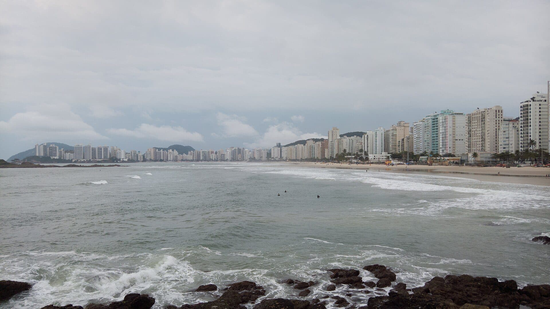 Vista da orla com faixa de areia e mar na Praia das Pitangueiras