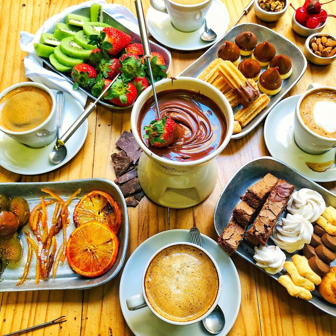 Fondue de chocolate servido com morangos, marshmallows e frutas