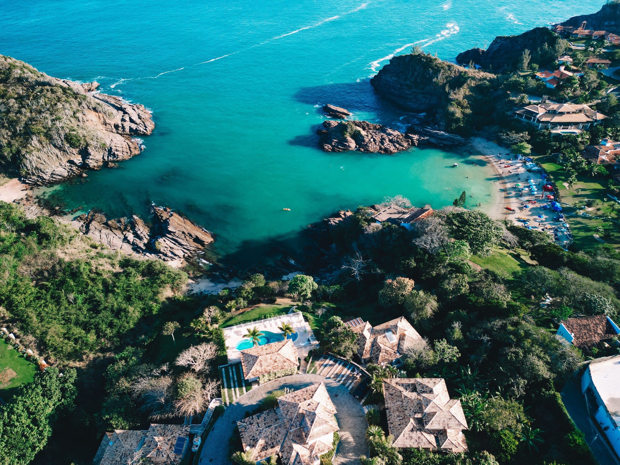 Vista aérea da Praia da Ferradurinha em Búzios com águas azul-turquesa e vegetação ao redor