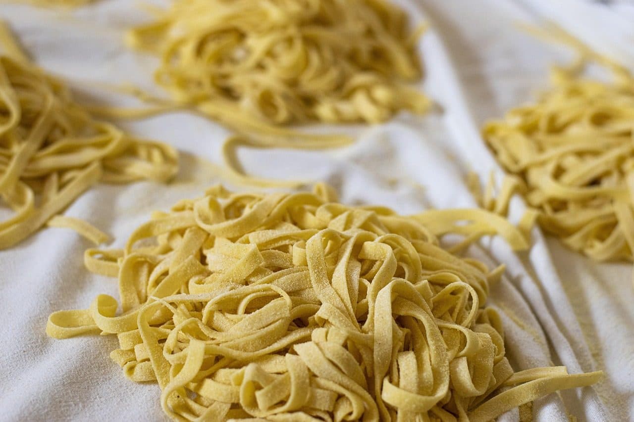 Massa fresca do tipo tagliatelle amarela em processo de secagem