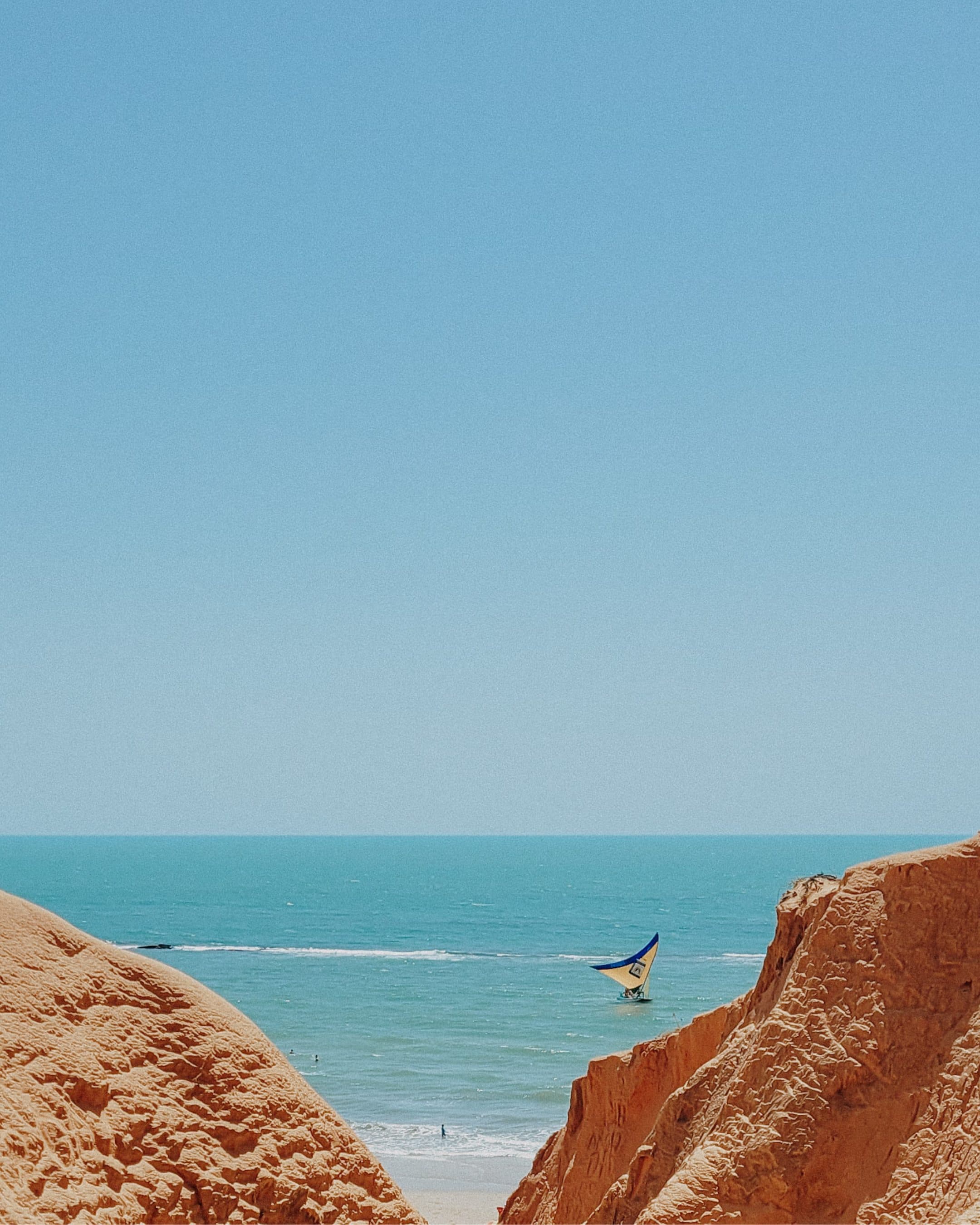 Paisagem litorânea de Canoa Quebrada com falésias e mar azul