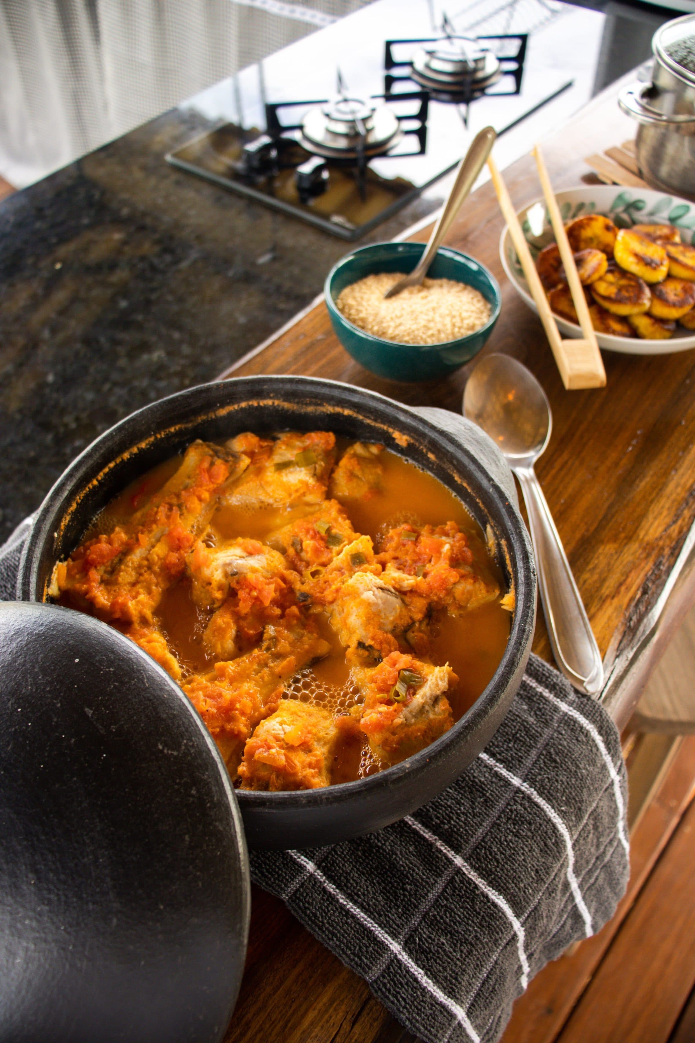 Moqueca servida em panela de barro acompanhada de arroz e banana-da-terra