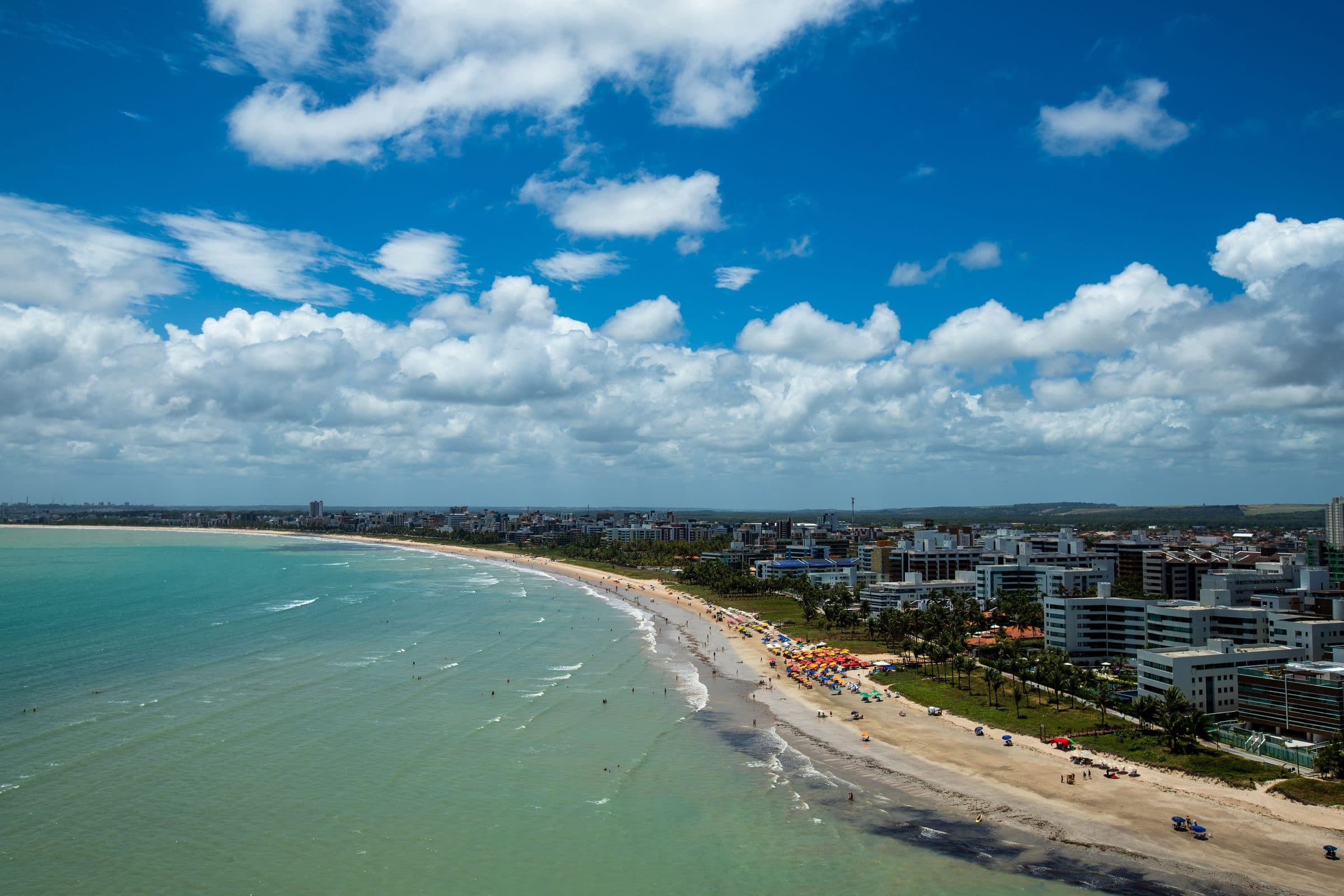 Vista aérea da Praia de Cabo Branco em João Pessoa com a orla urbana e o mar