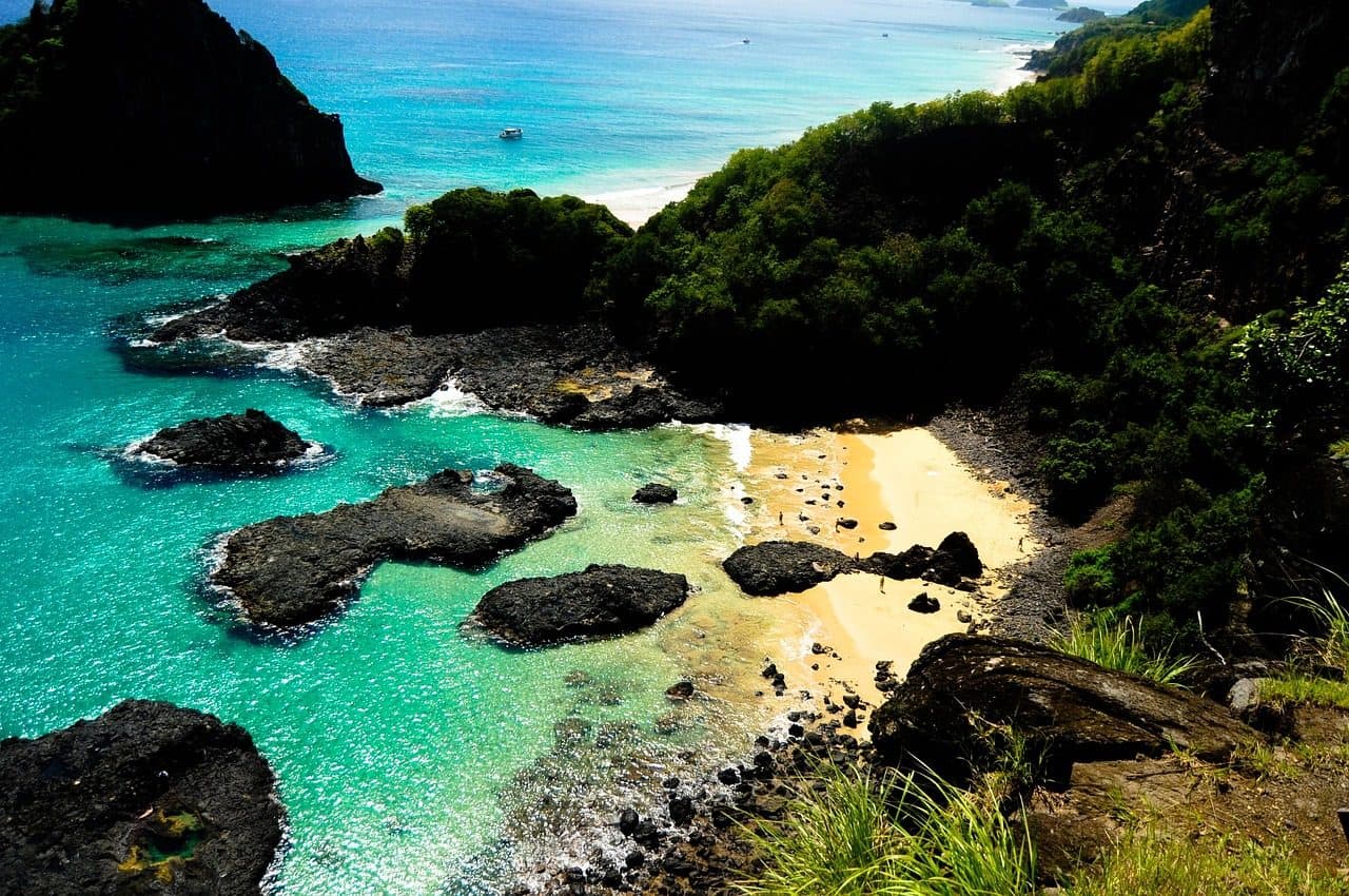 Paisagem de Fernando de Noronha com um barco no mar próximo à praia