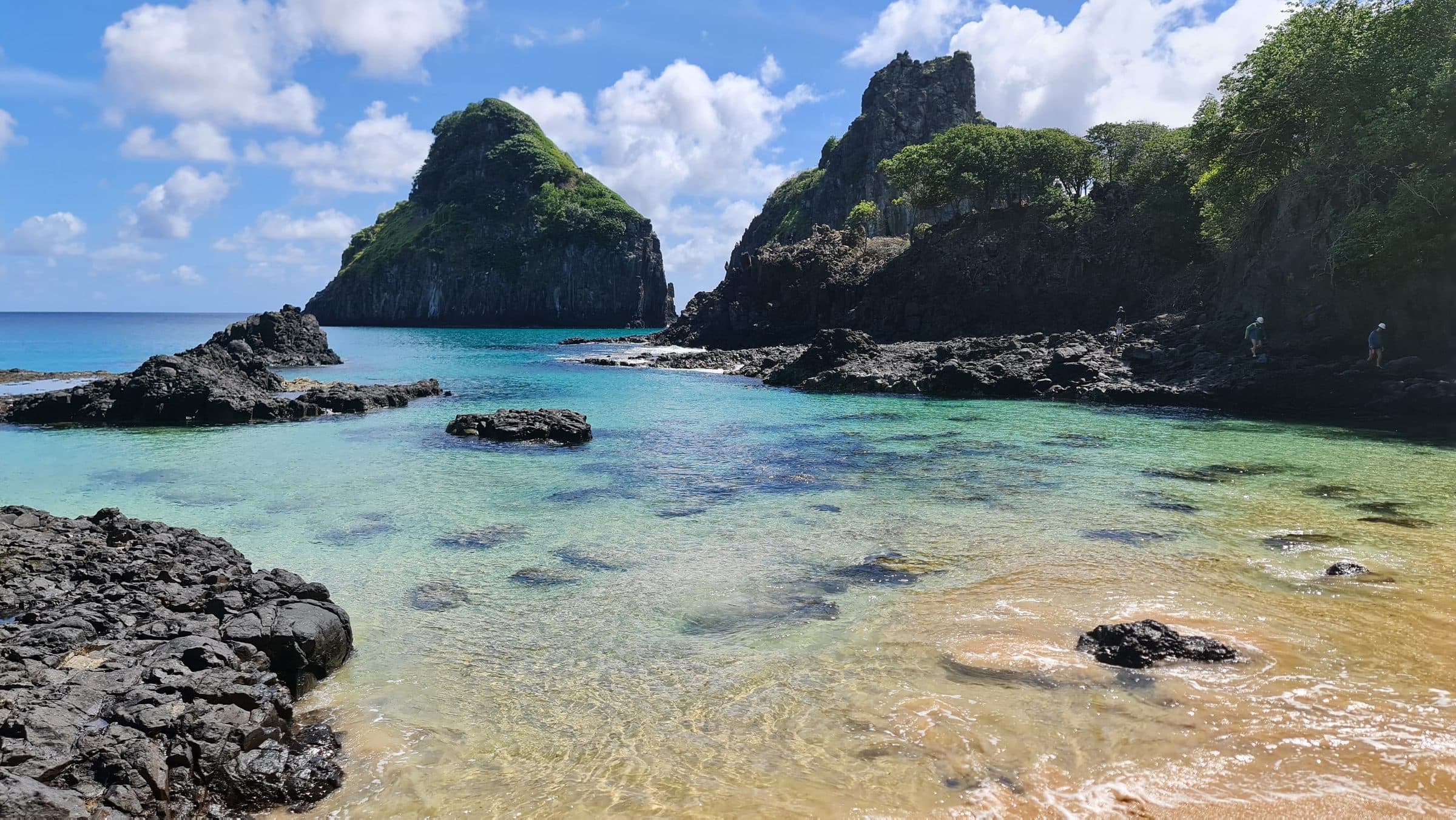 Águas transparentes e formações rochosas na costa de Fernando de Noronha