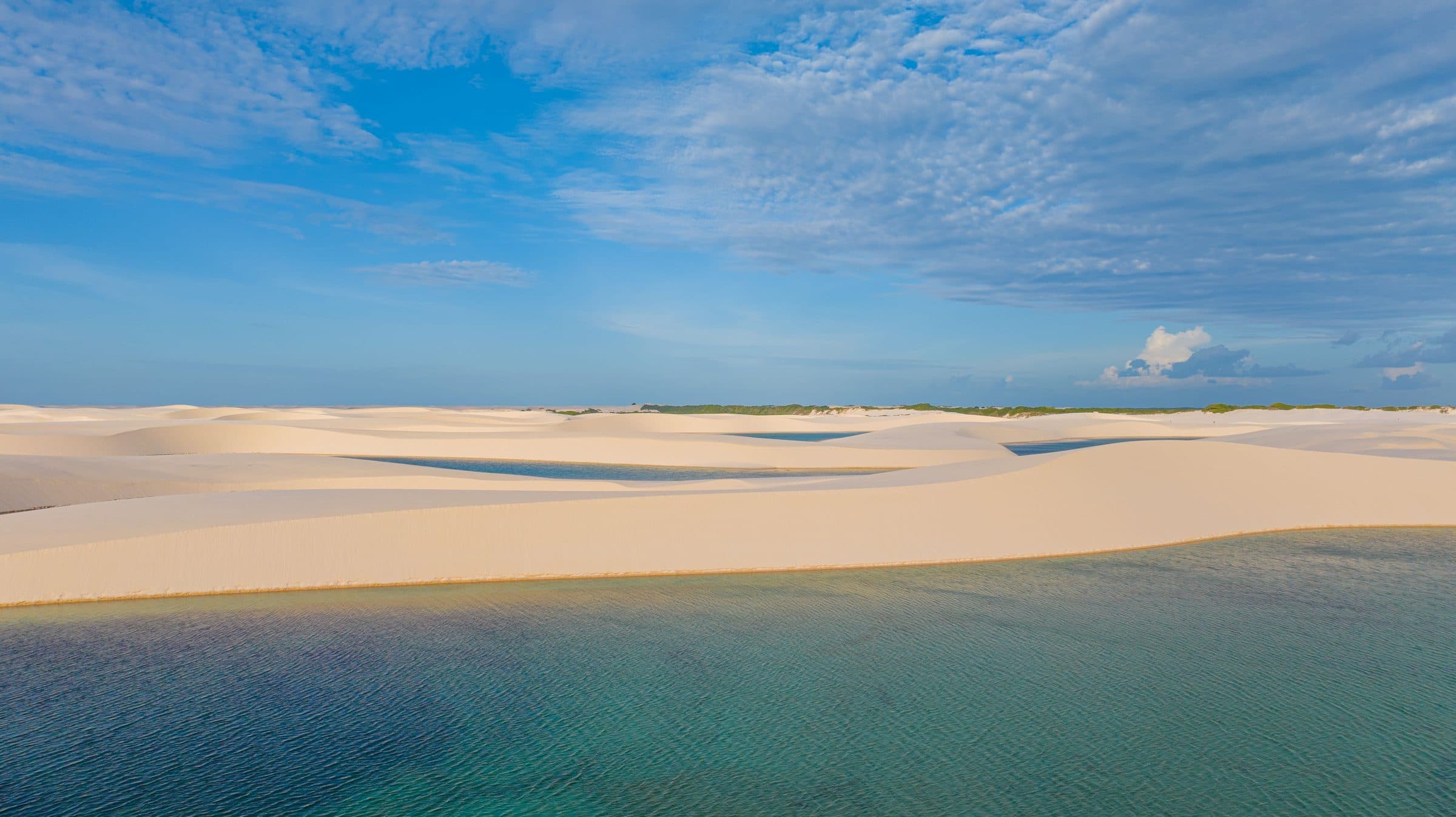 Paisagem de dunas de areia e lagoas nos Lençóis Maranhenses