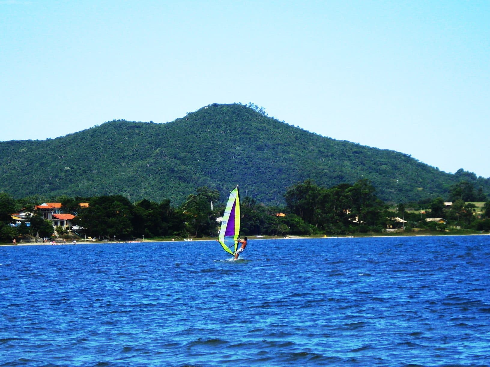 Pessoa praticando windsurf na Lagoa de Ibiraquera