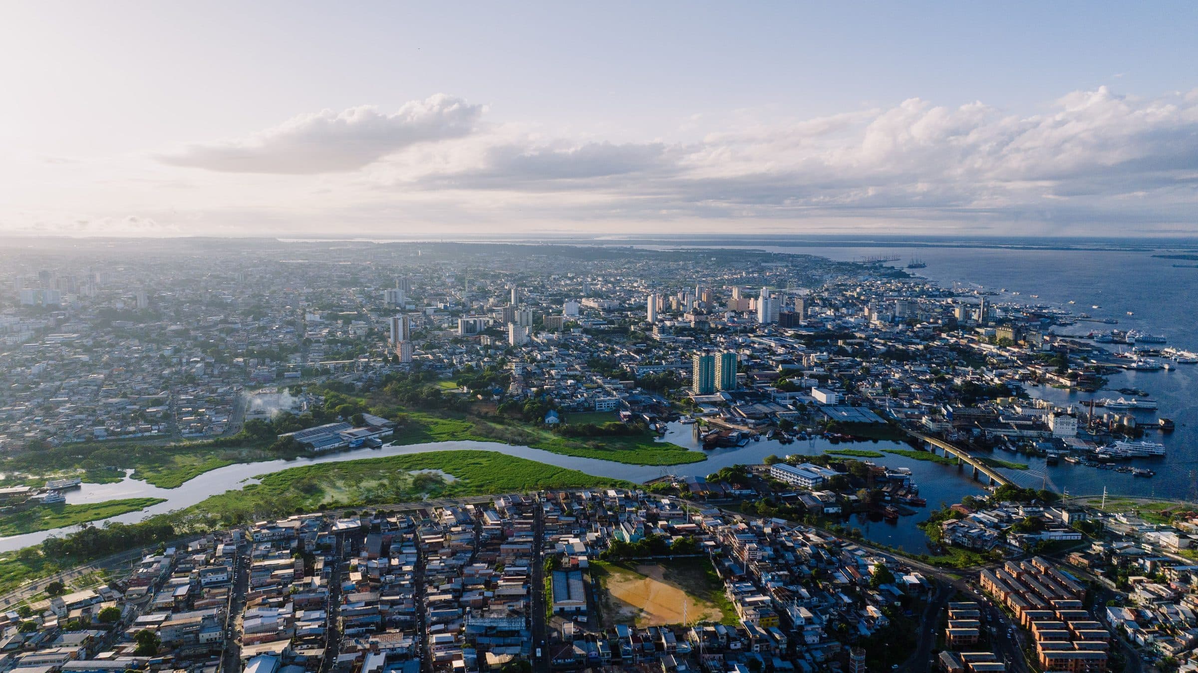 Vista aérea do bairro de São Raimundo em Manaus com rio e paisagem urbana