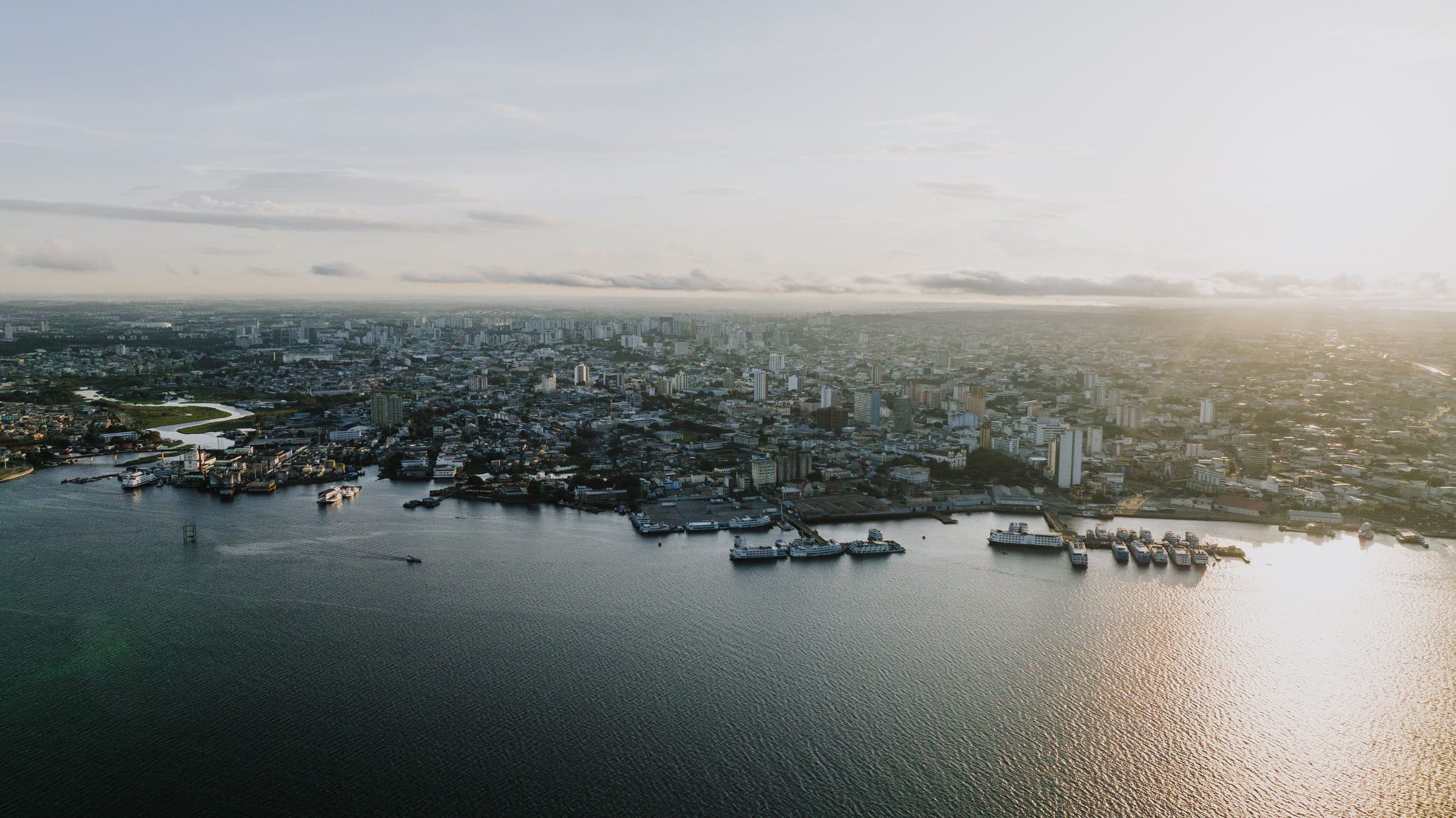Vista aérea da cidade e da orla de Manaus ao pôr do sol