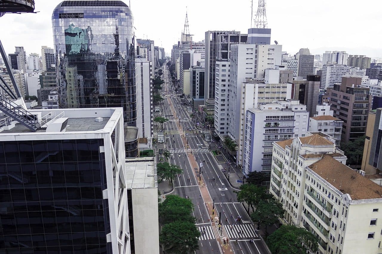 Vista urbana da Avenida Paulista em São Paulo com edifícios modernos e tráfego na rua