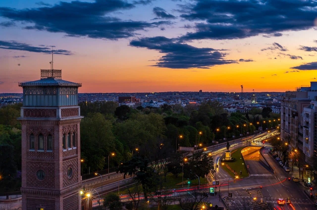 Paisagem urbana de Madrid com edifícios e monumentos sob o céu com nuvens ao pôr do sol