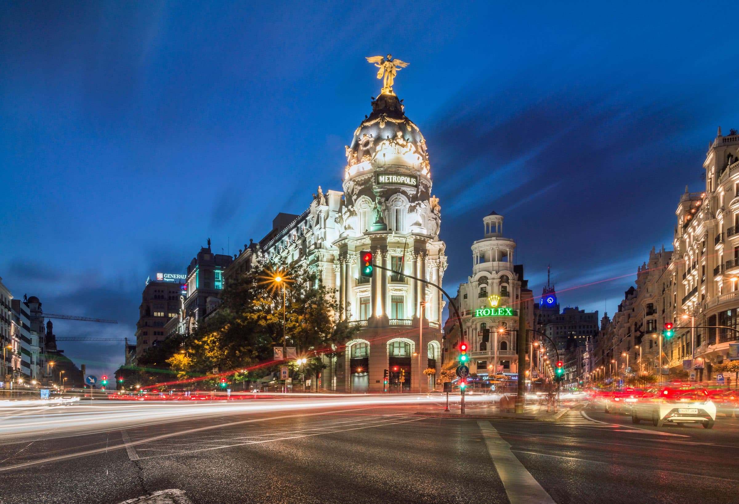 Vista noturna do Edifício Metrópolis com luzes da cidade e rastros de tráfego em Madrid