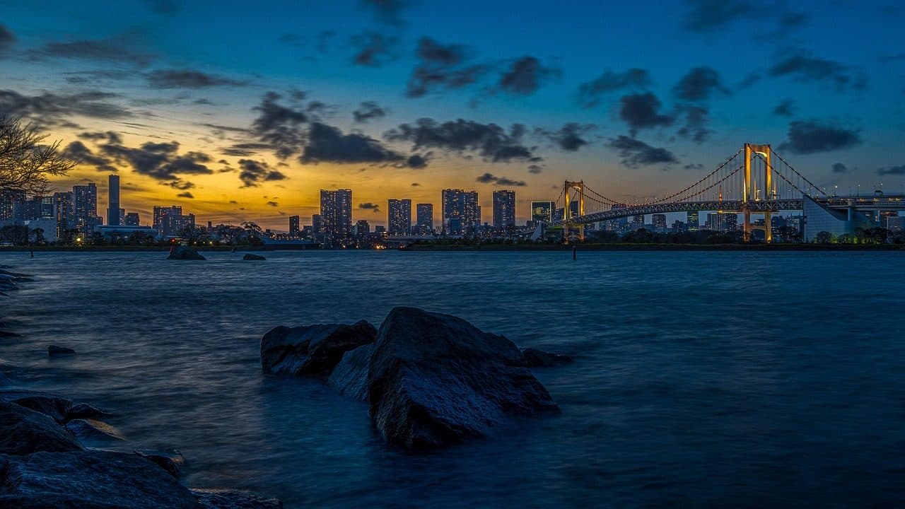 Ponte iluminada e arquitetura urbana de Tóquio durante o pôr do sol