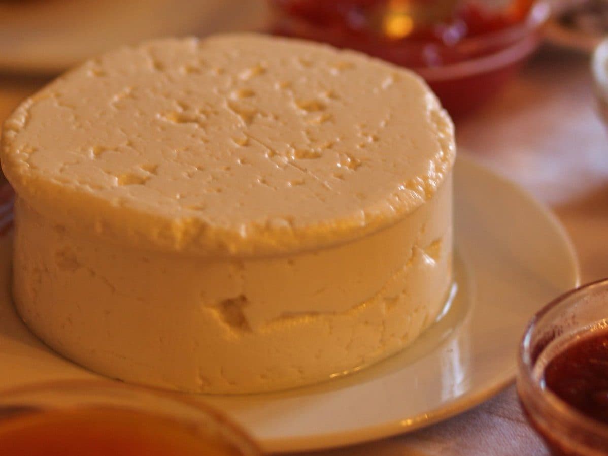 Porção de queijo Rabaçal fresco servida sobre a mesa
