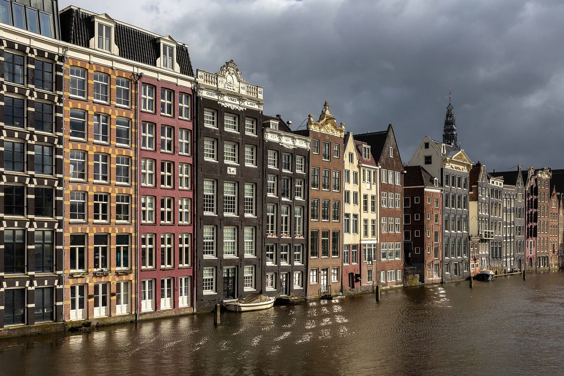 Casas coloridas à beira do canal na avenida Damrak em Amsterdã durante a hora dourada