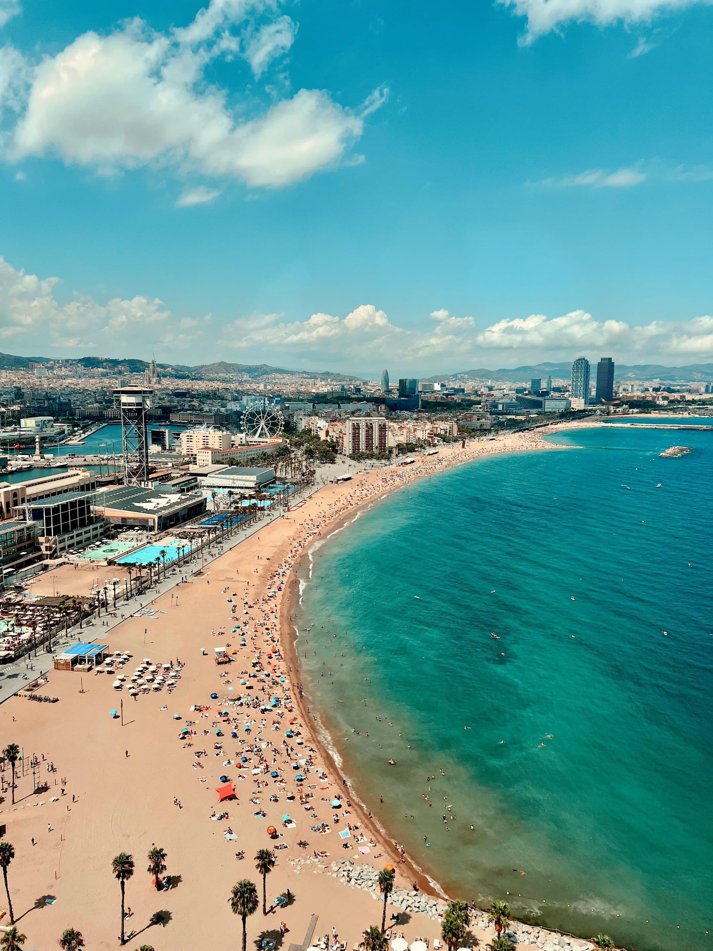 Vista aérea da praia ensolarada de Barcelona com a cidade e o mar ao fundo