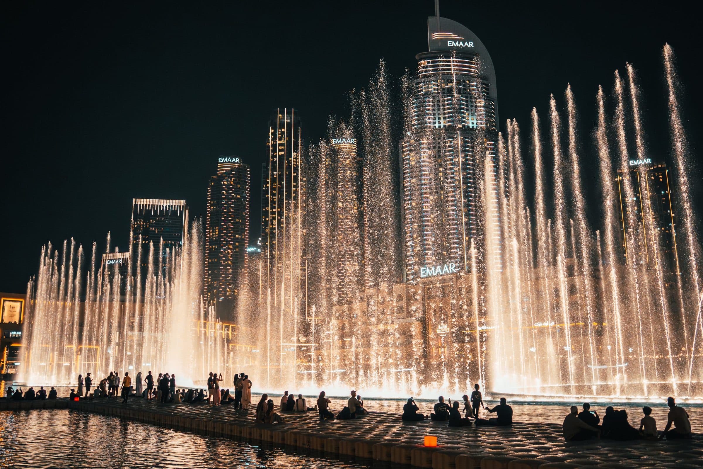 Vista noturna da Dubai Fountain com arranha-céus da cidade ao fundo