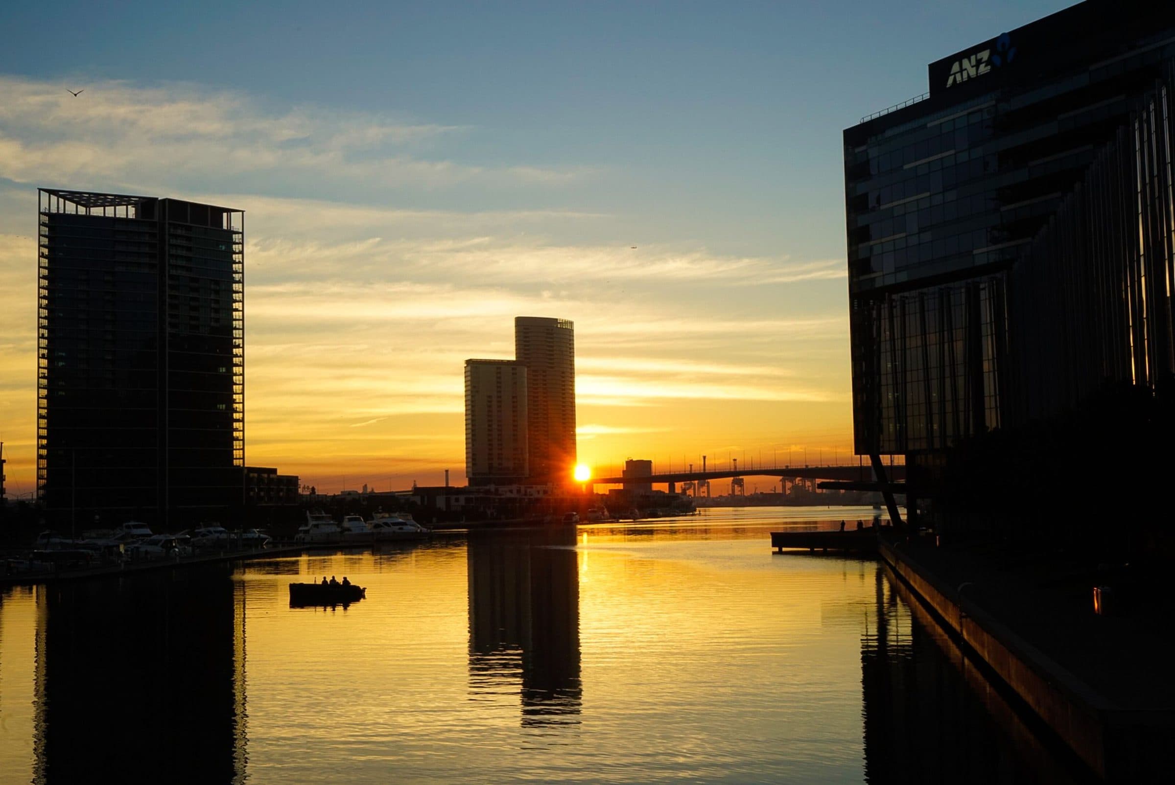 Pôr do sol sobre Docklands refletido na água em Melbourne