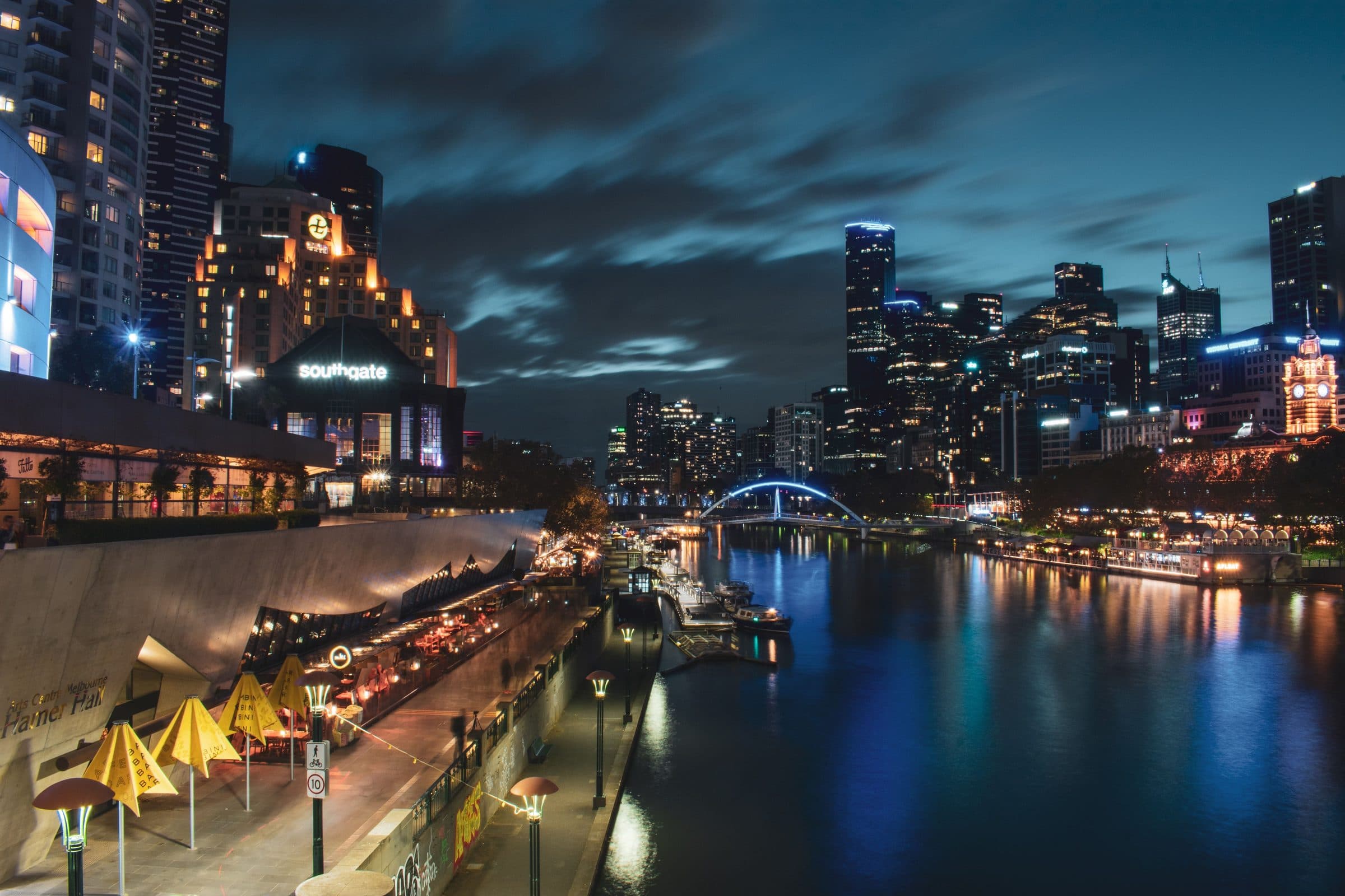 Skyline de Melbourne iluminado à noite com luzes da cidade refletidas no Rio Yarra