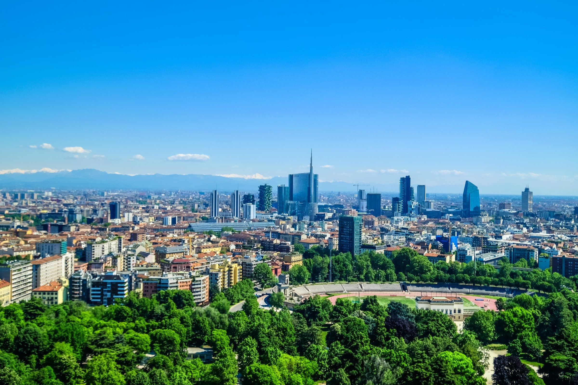 Vista panorâmica de Milão com arranha-céus modernos e áreas verdes sob céu azul