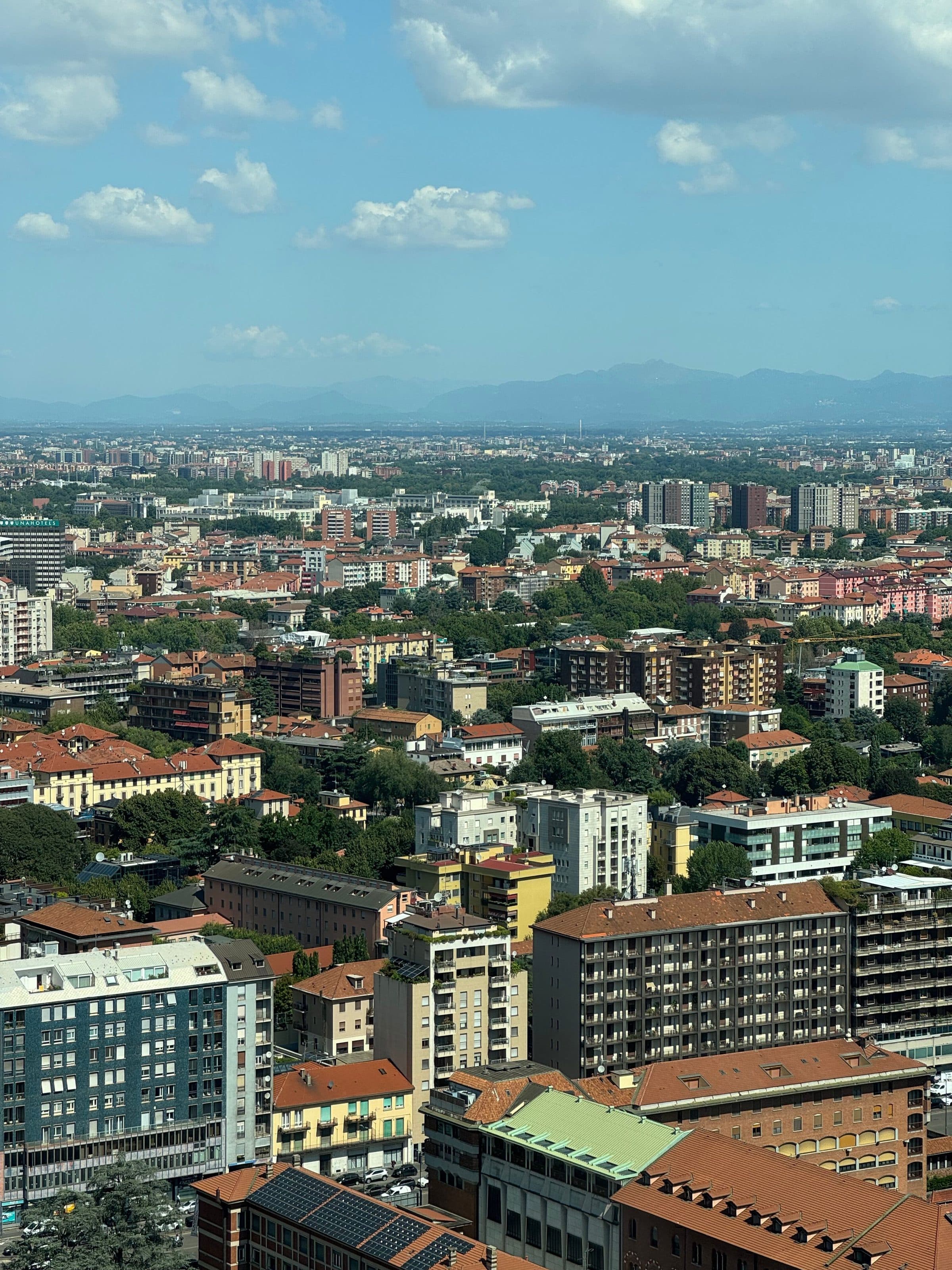 Vista aérea da arquitetura urbana de Milão em um dia ensolarado com montanhas ao fundo