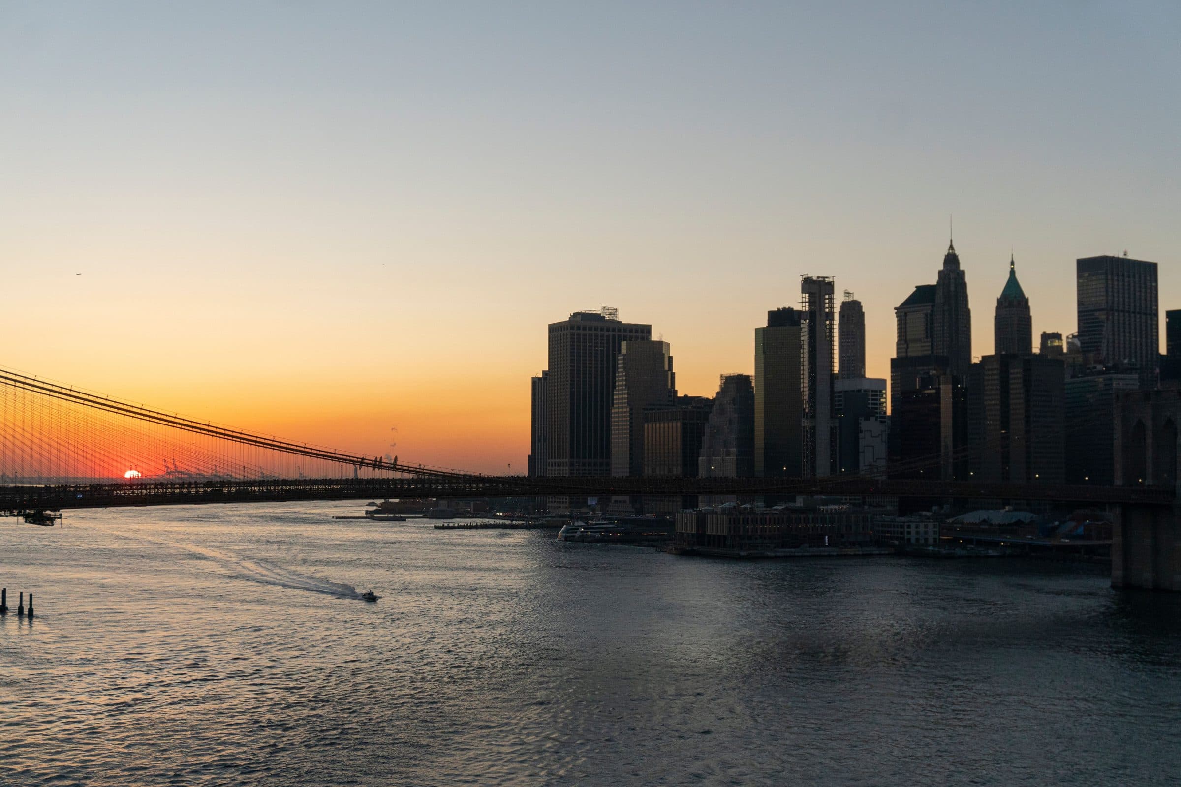 Pôr do sol sobre a Brooklyn Bridge e os arranha-céus de Manhattan na orla de Nova York