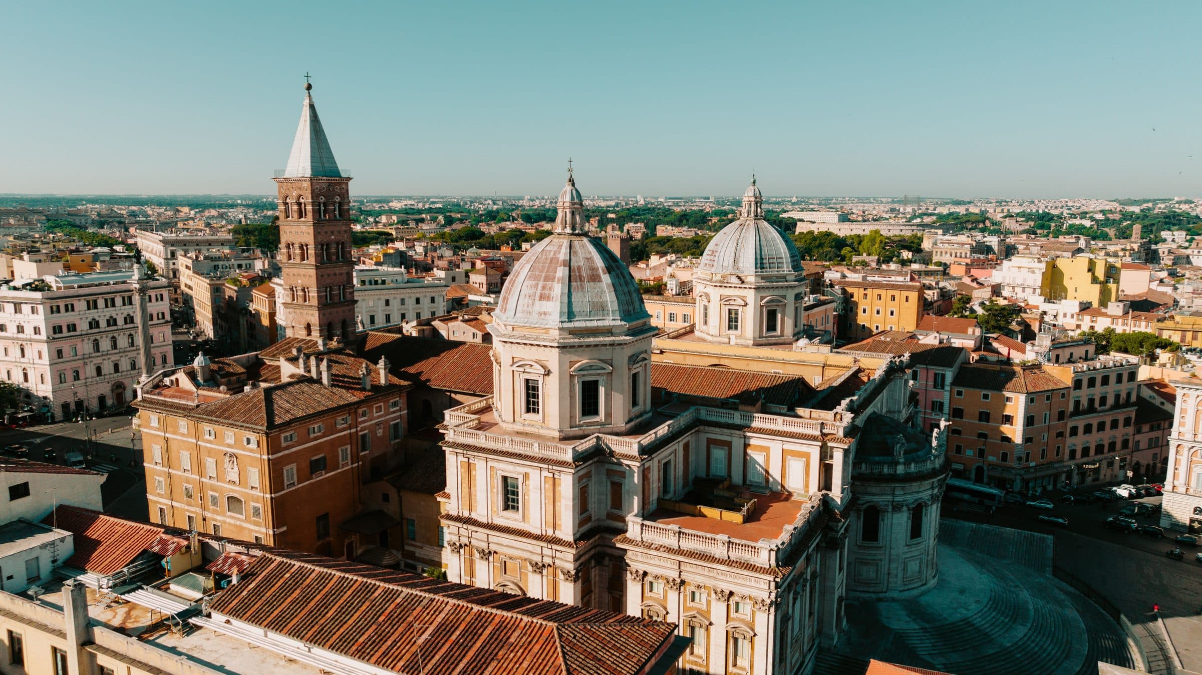 Vista aérea da arquitetura histórica de Roma com cúpulas e torres sob céu limpo