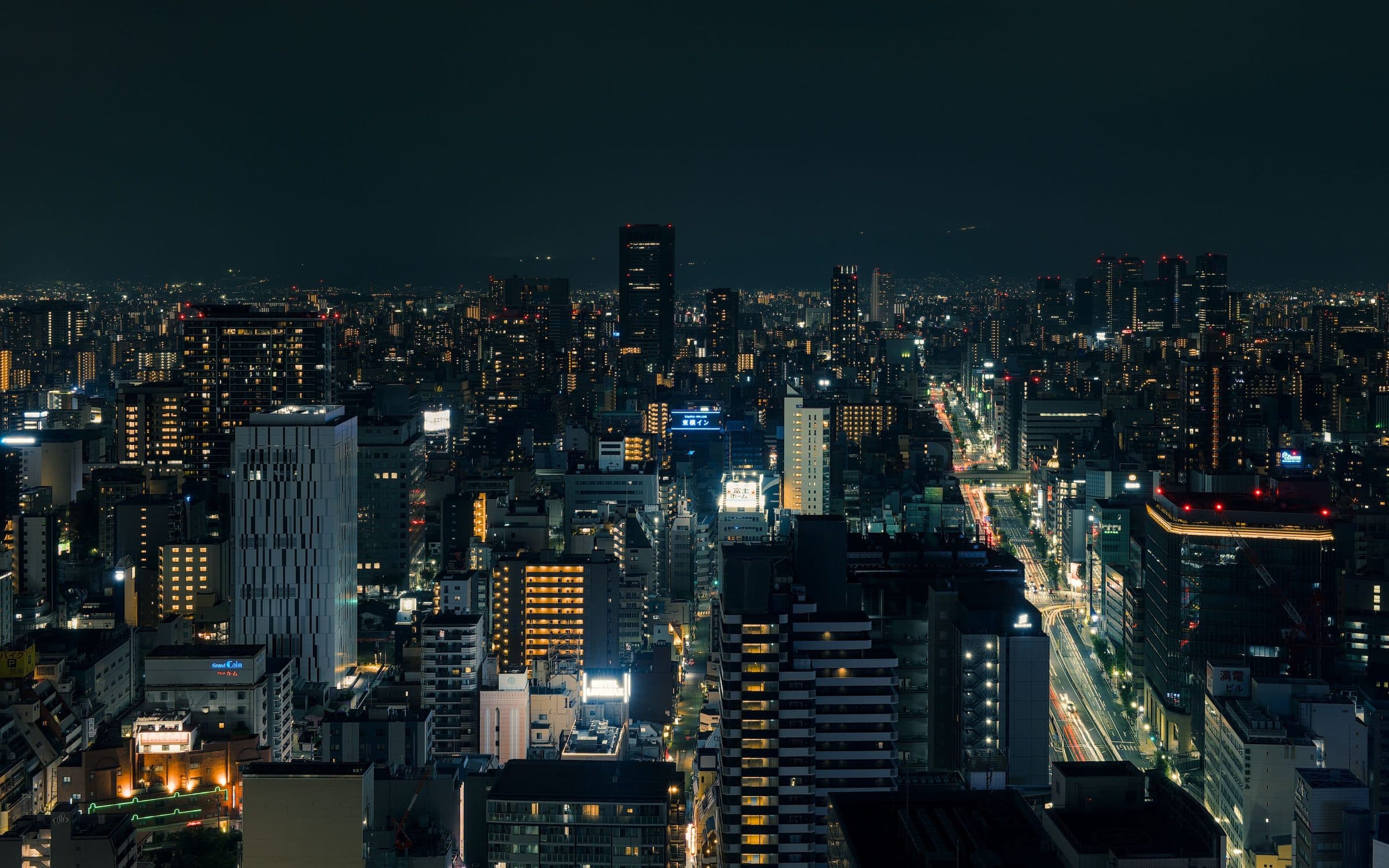 Vista noturna da cidade de Osaka com edifícios e ruas iluminadas