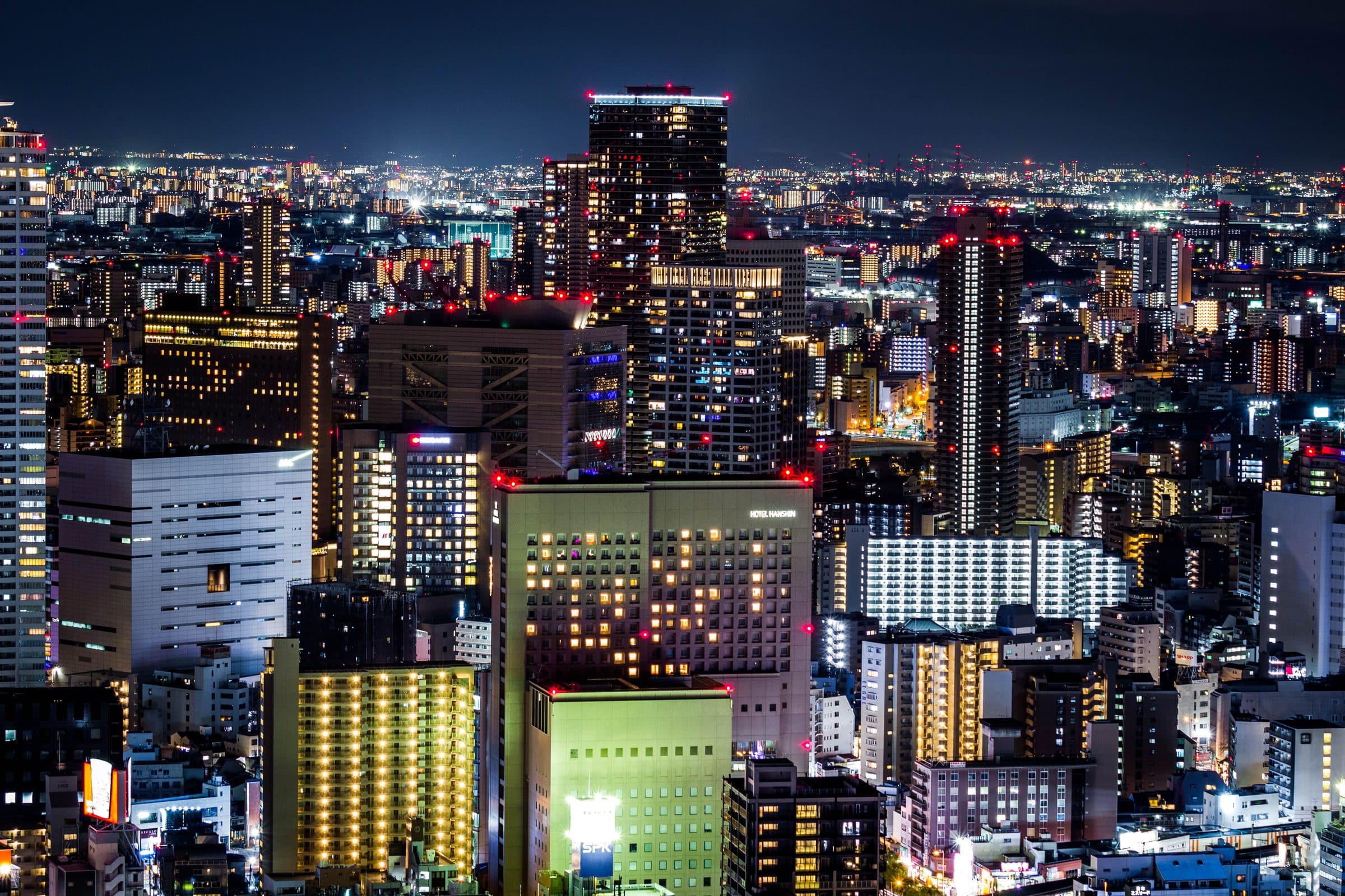 Vista noturna de Osaka com arranha-céus modernos e luzes da cidade