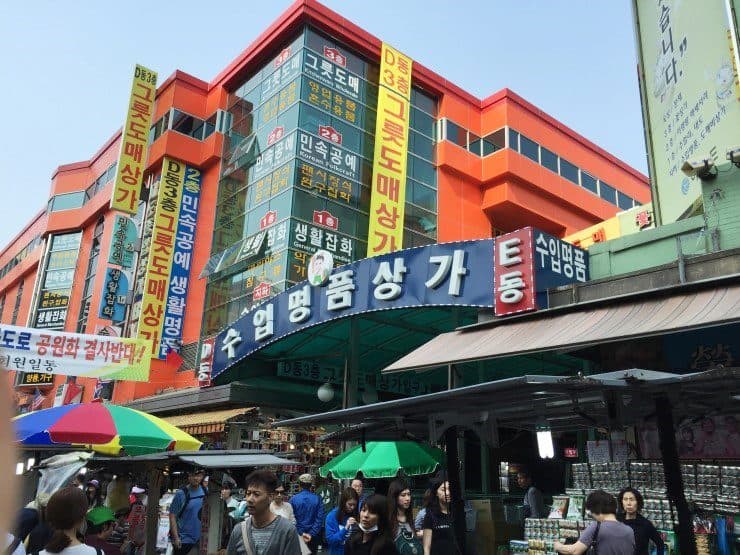 Vista do movimentado Mercado Namdaemun com pedestres e lojas