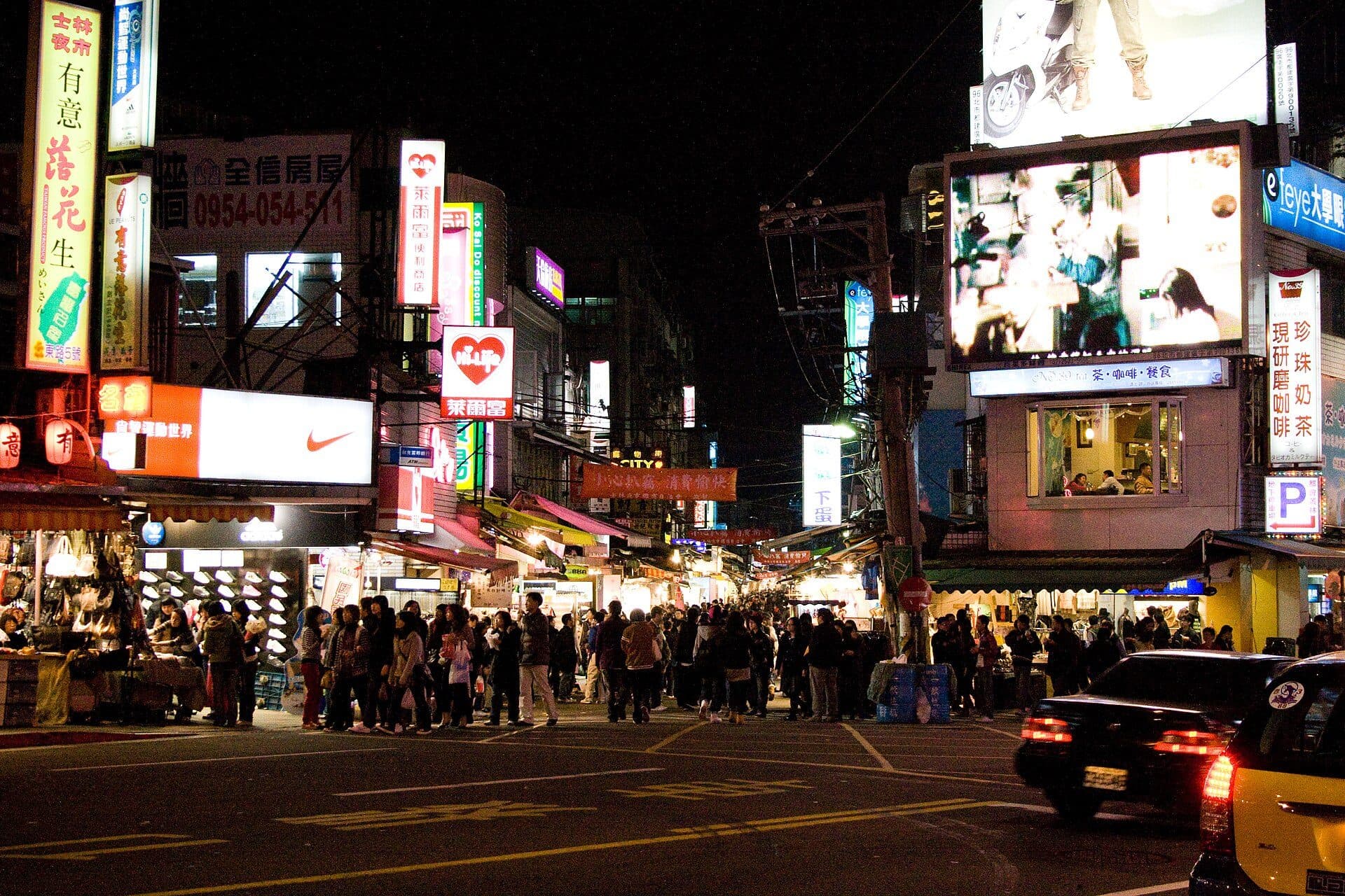Barracas e movimentação de pessoas no Shilin Night Market à noite