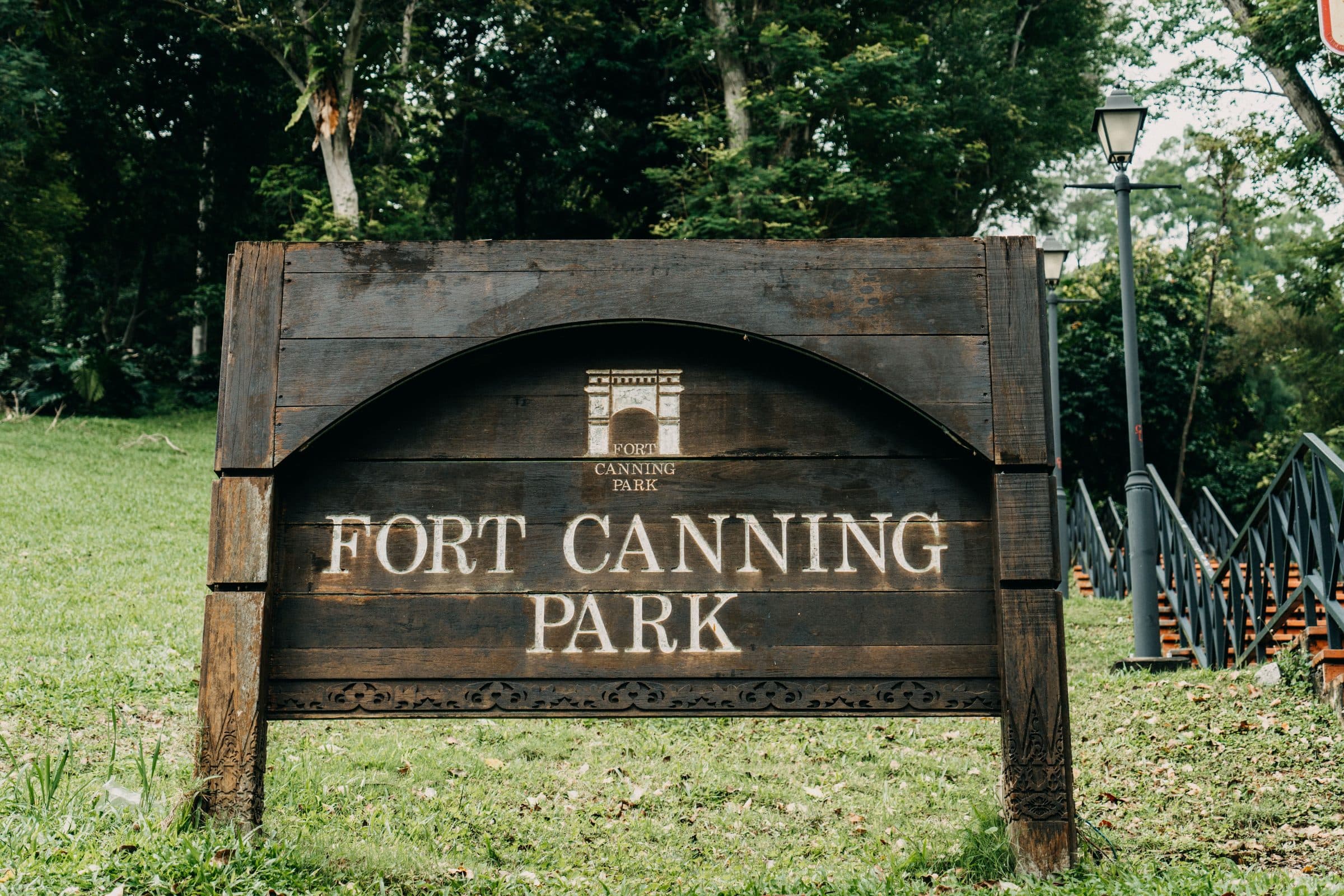 Placa de madeira do Fort Canning Park cercada por vegetação em Singapura
