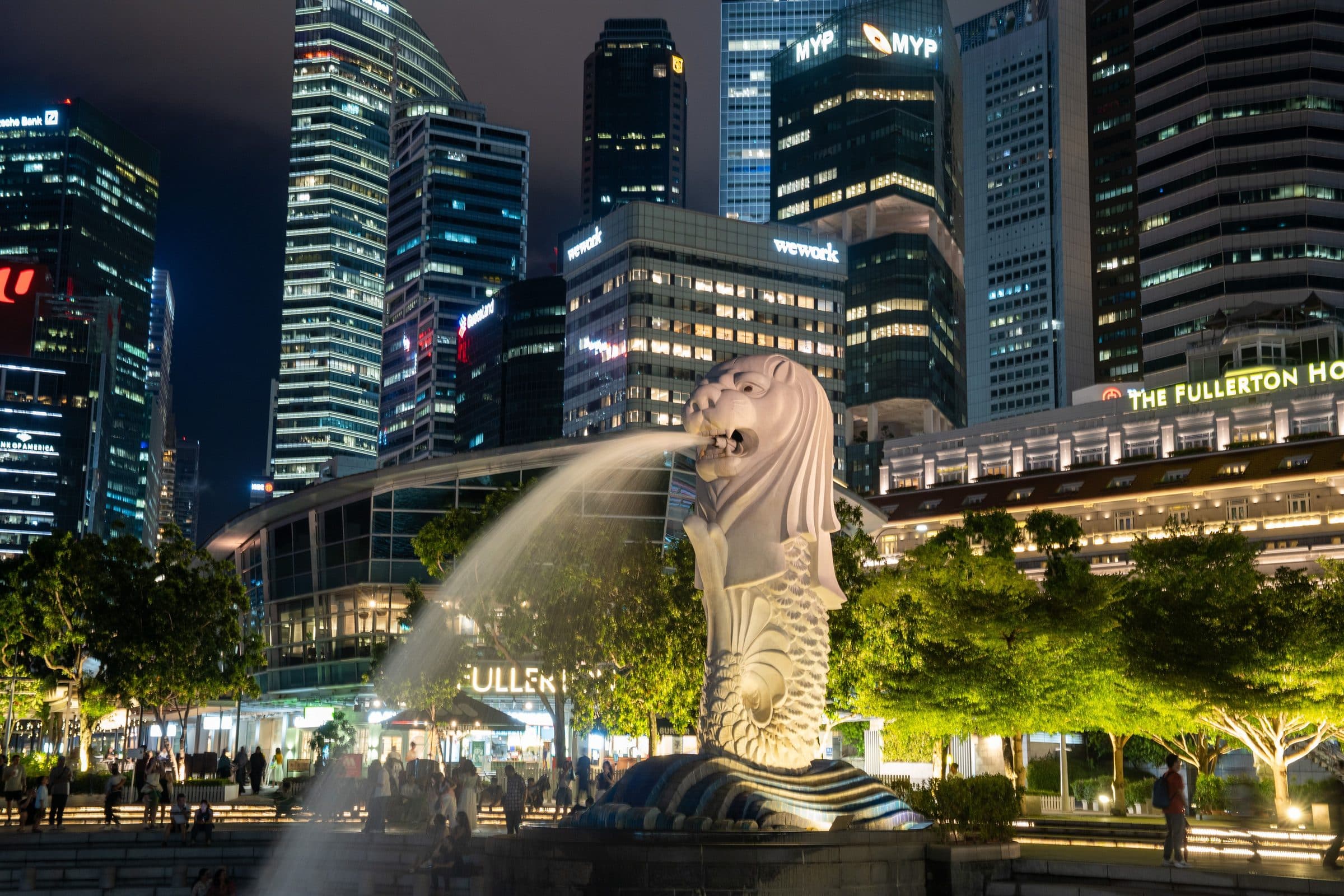 Estátua do Merlion no Parque Merlion com o horizonte urbano de Singapura à noite