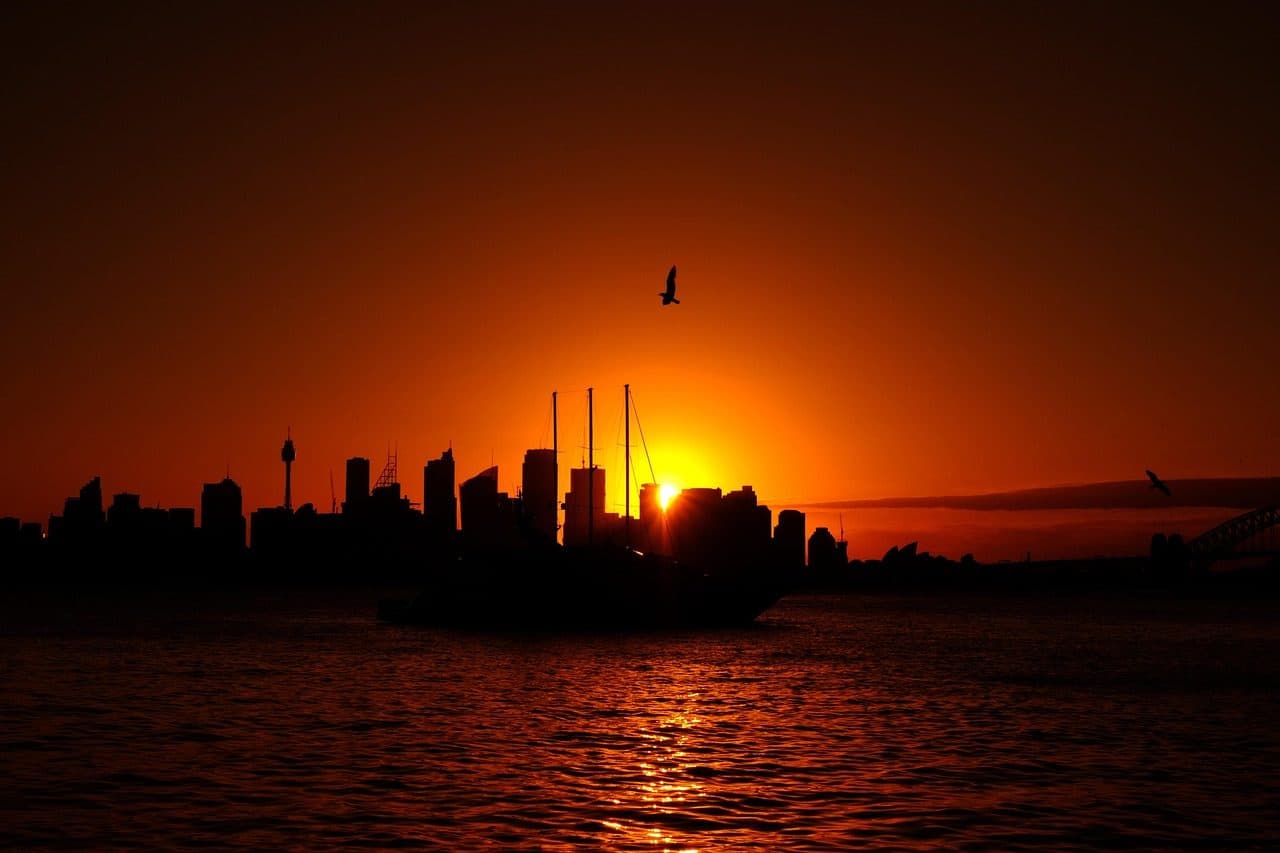 Vista panorâmica de Sydney Harbour com o horizonte urbano da cidade ao pôr do sol