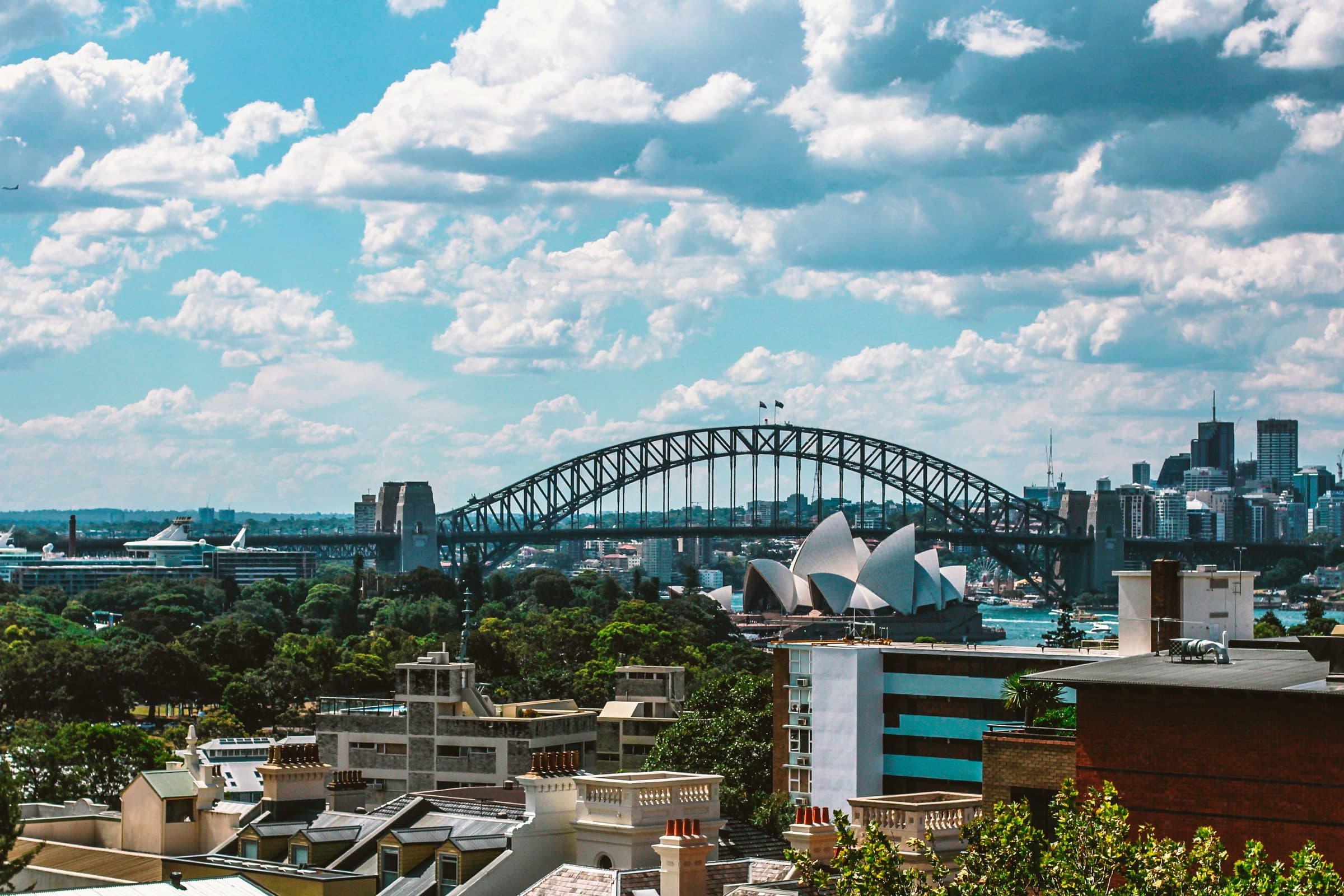 Vista da Sydney Harbour Bridge e da Sydney Opera House em um dia ensolarado com a cidade ao fundo