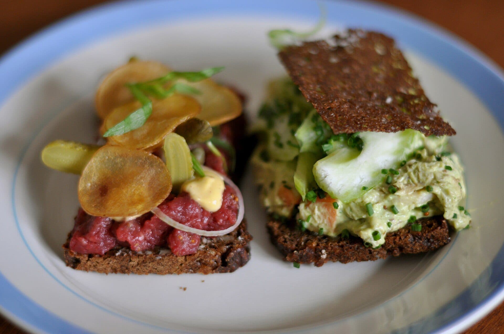 Sanduíches abertos smørrebrød servidos com carne tártaro e salada de frango
