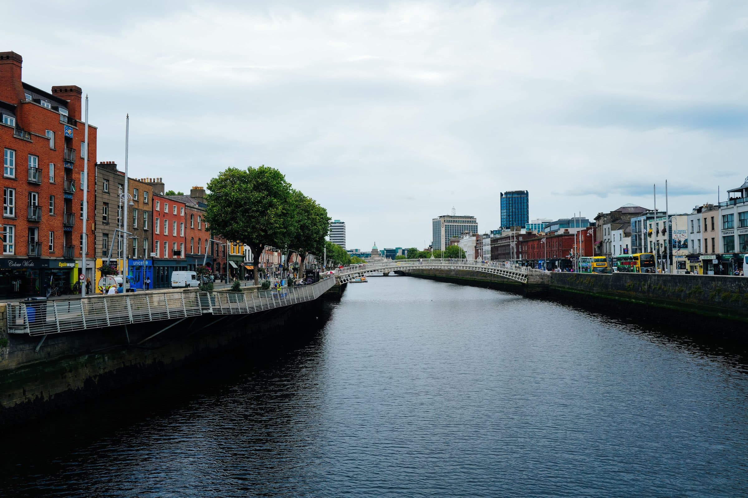 Vista da ponte Ha'penny Bridge sobre o Rio Liffey com a arquitetura urbana de Dublin ao fundo