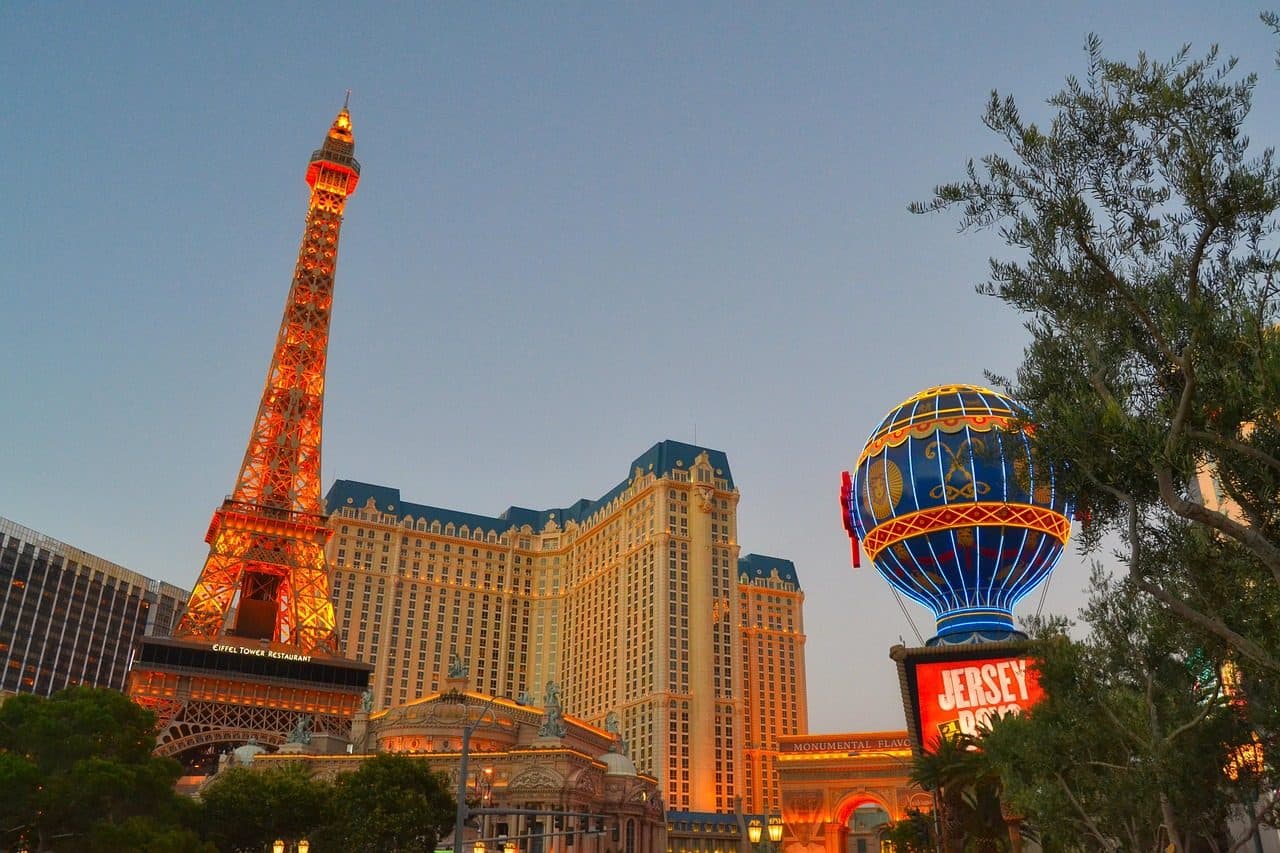 Vista noturna do hotel Paris e da réplica da Torre Eiffel iluminada em Las Vegas