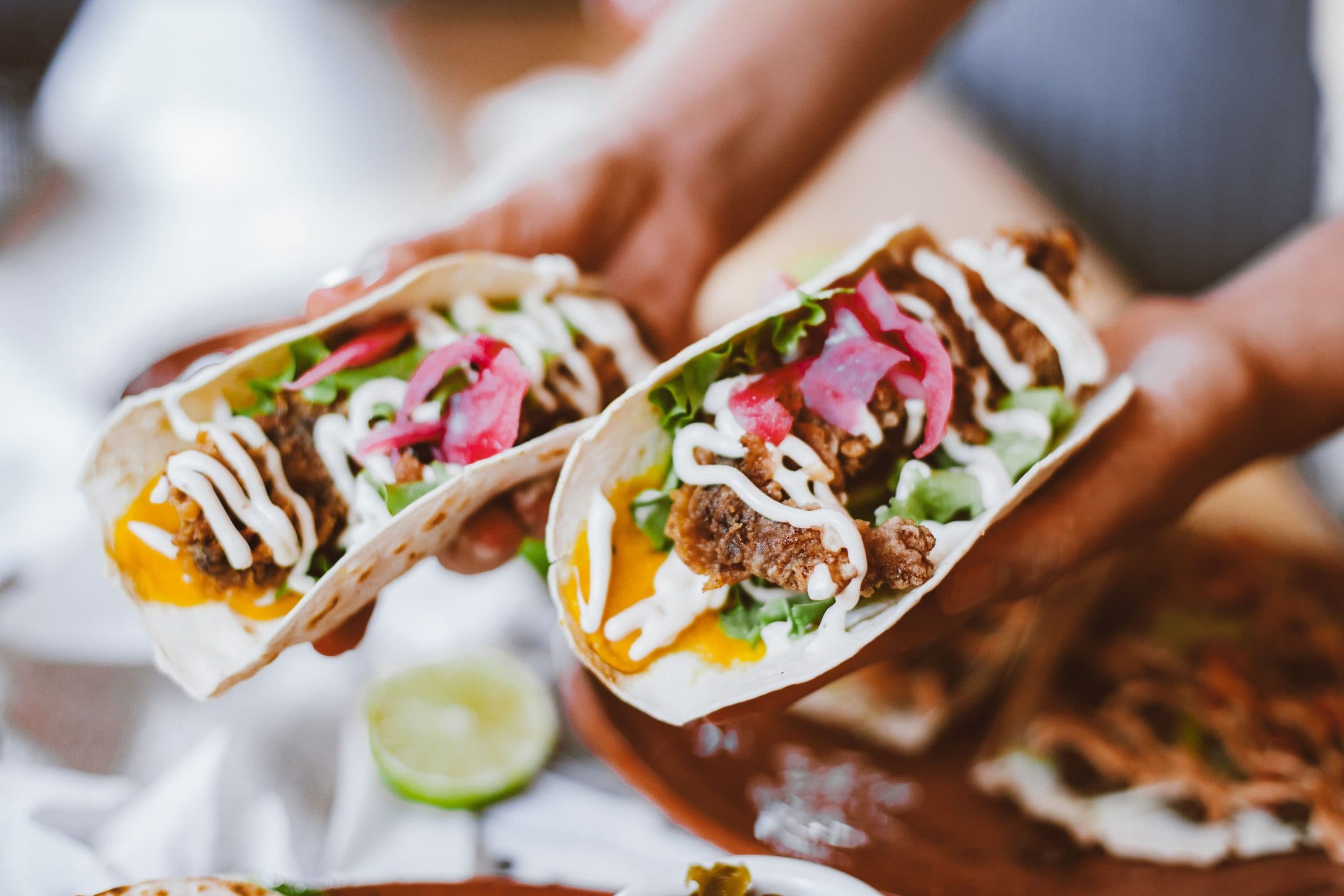 Tacos servidos com recheio de alface, queijo e cebola em conserva