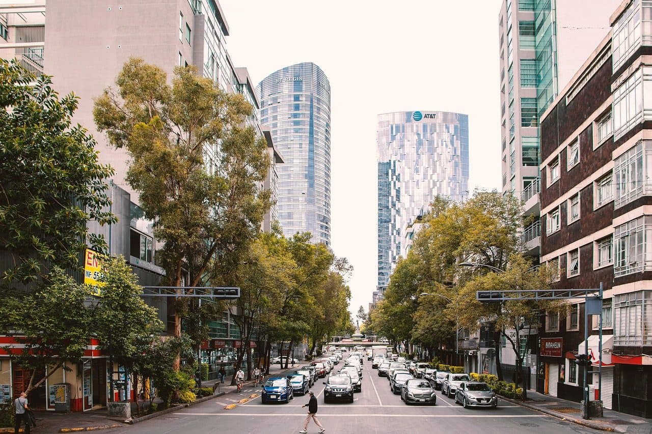 Rua urbana com trânsito de veículos e edifícios na Cidade do México