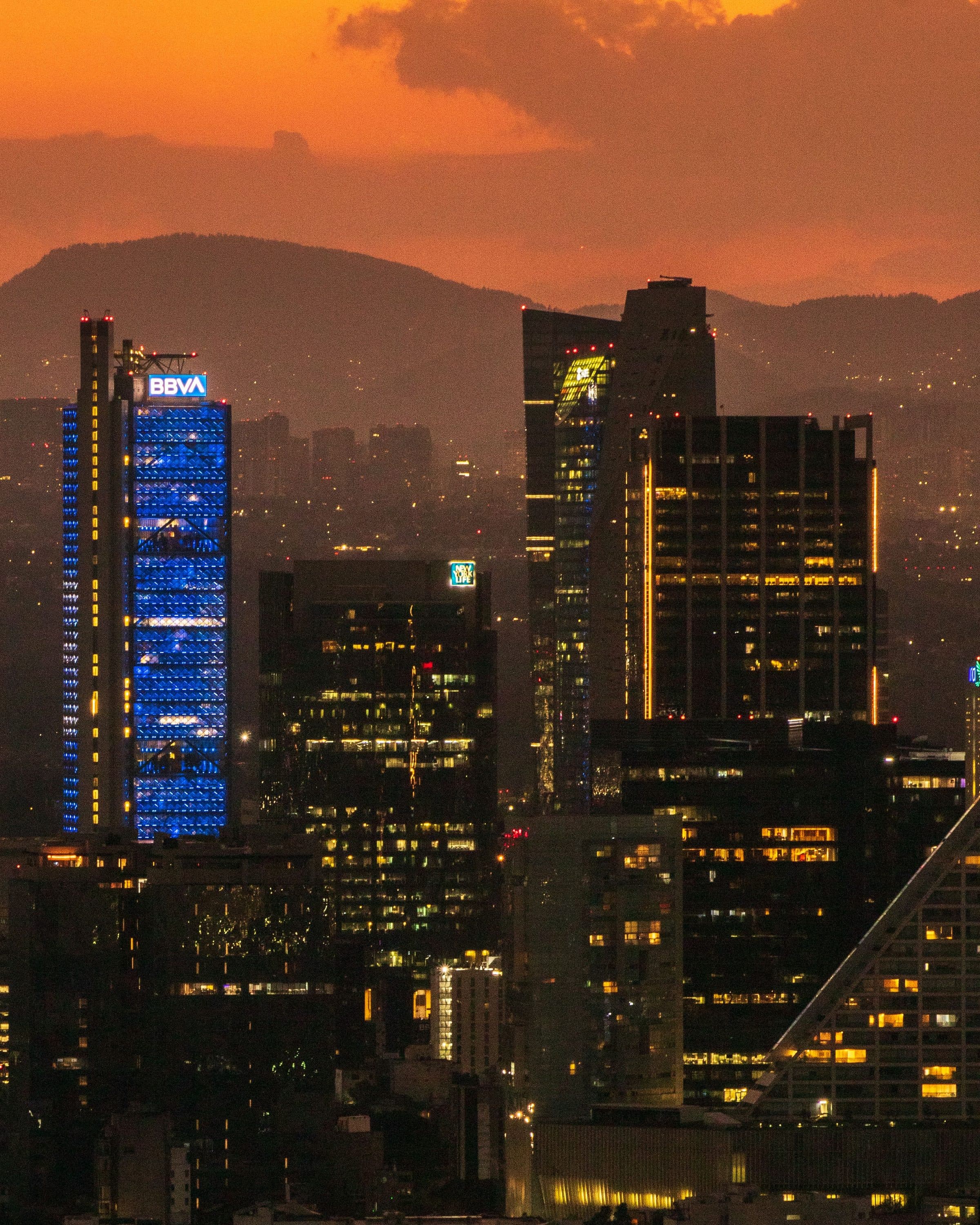 Arranha-céus modernos e iluminados no horizonte da Cidade do México ao pôr do sol