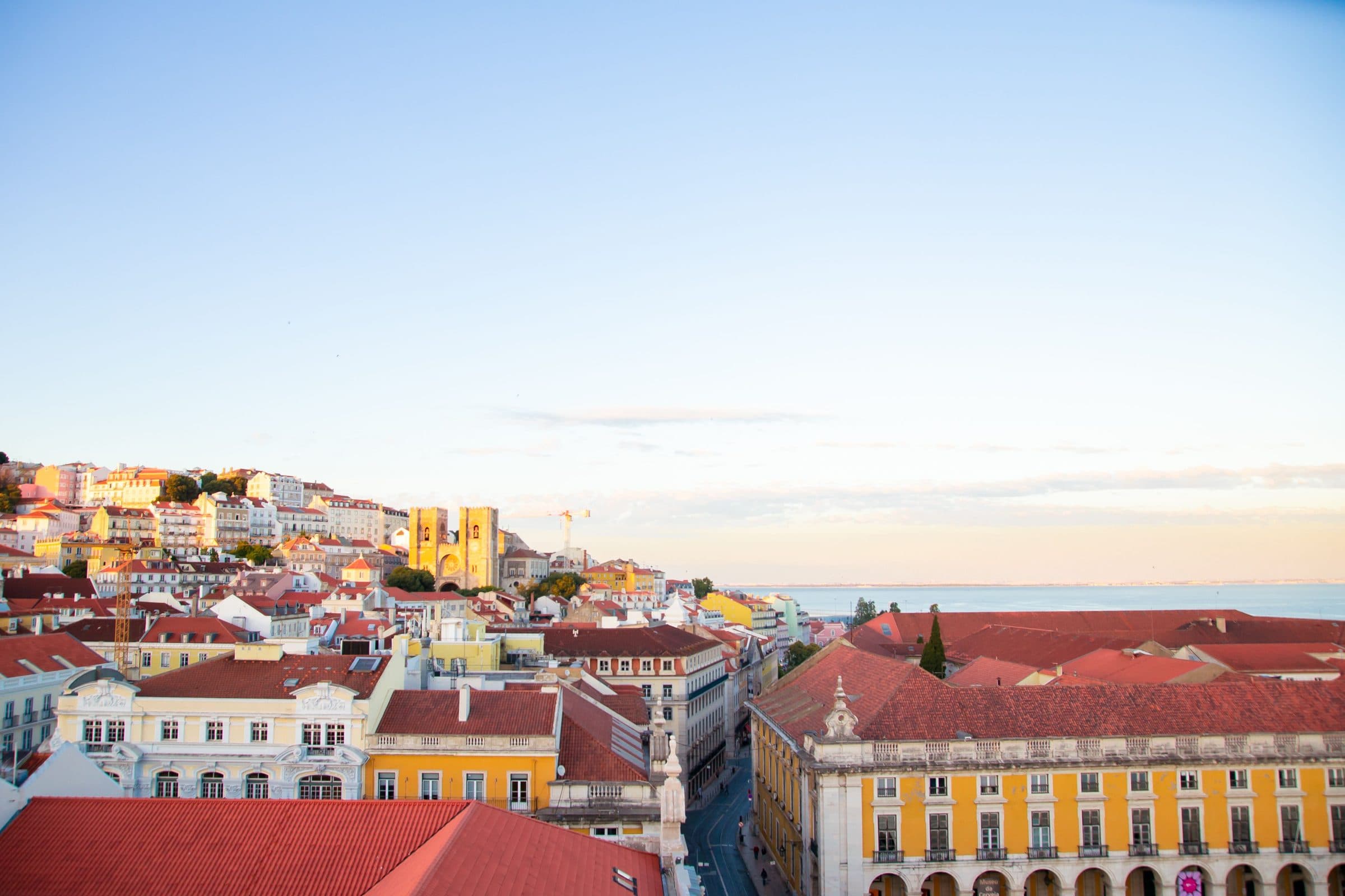 Vista de telhados residenciais modernos em Lisboa no início da noite sob céu azul limpo