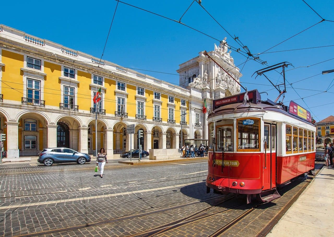 Bonde elétrico percorre rua com edifícios históricos em Alfama, Lisboa